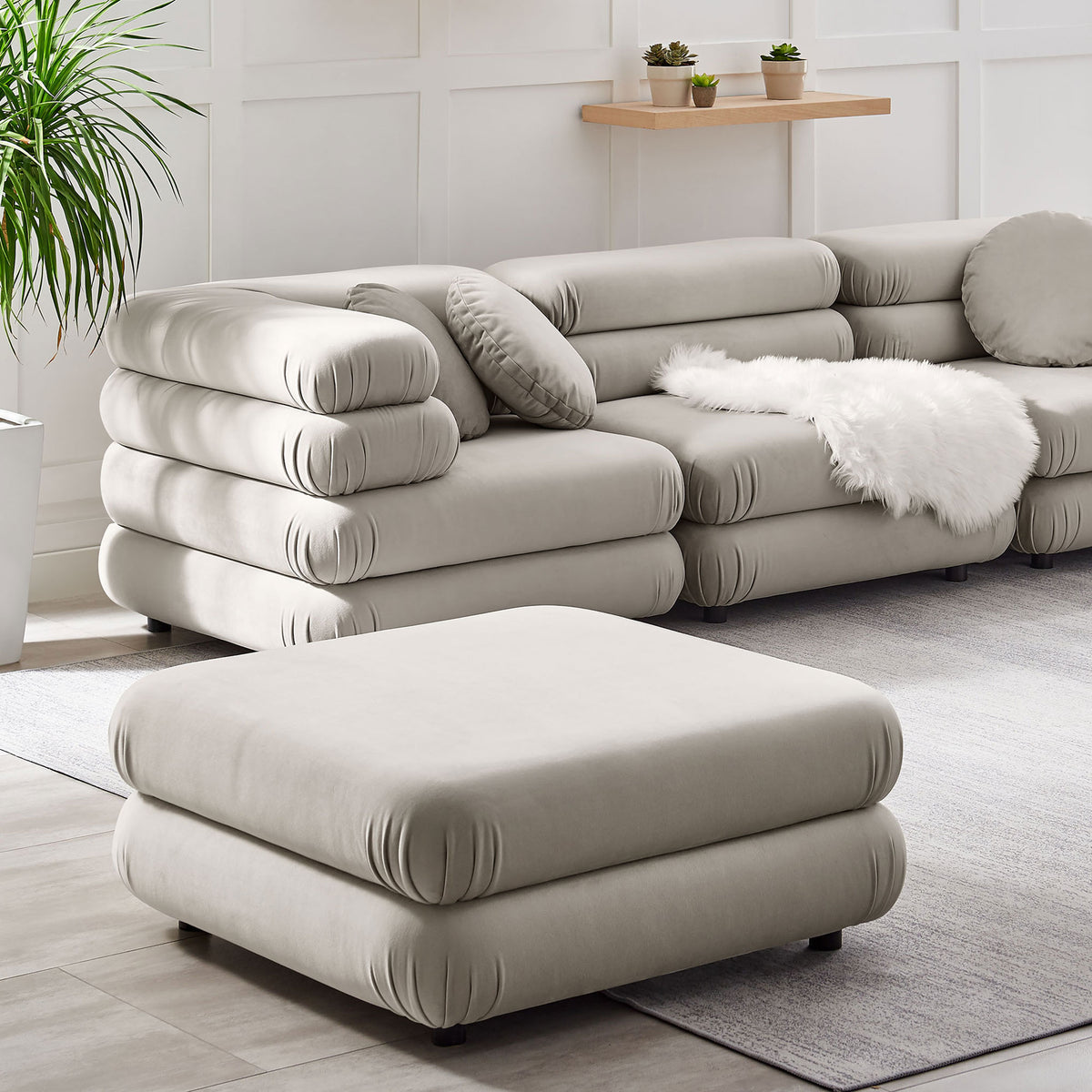 Almond velvet ottoman styled with matching modular seating to create a cozy modern lounge || EEI-6899-ALM || front_angle_room