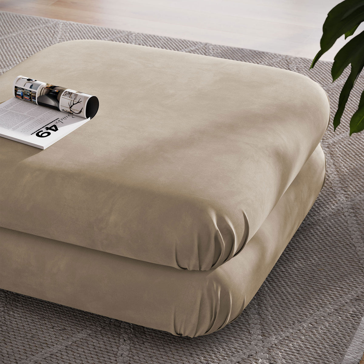 Generous square ottoman in taupe velvet used as a coffee table with magazine atop in a modern room || EEI-6899-TAU || top_angle_room
