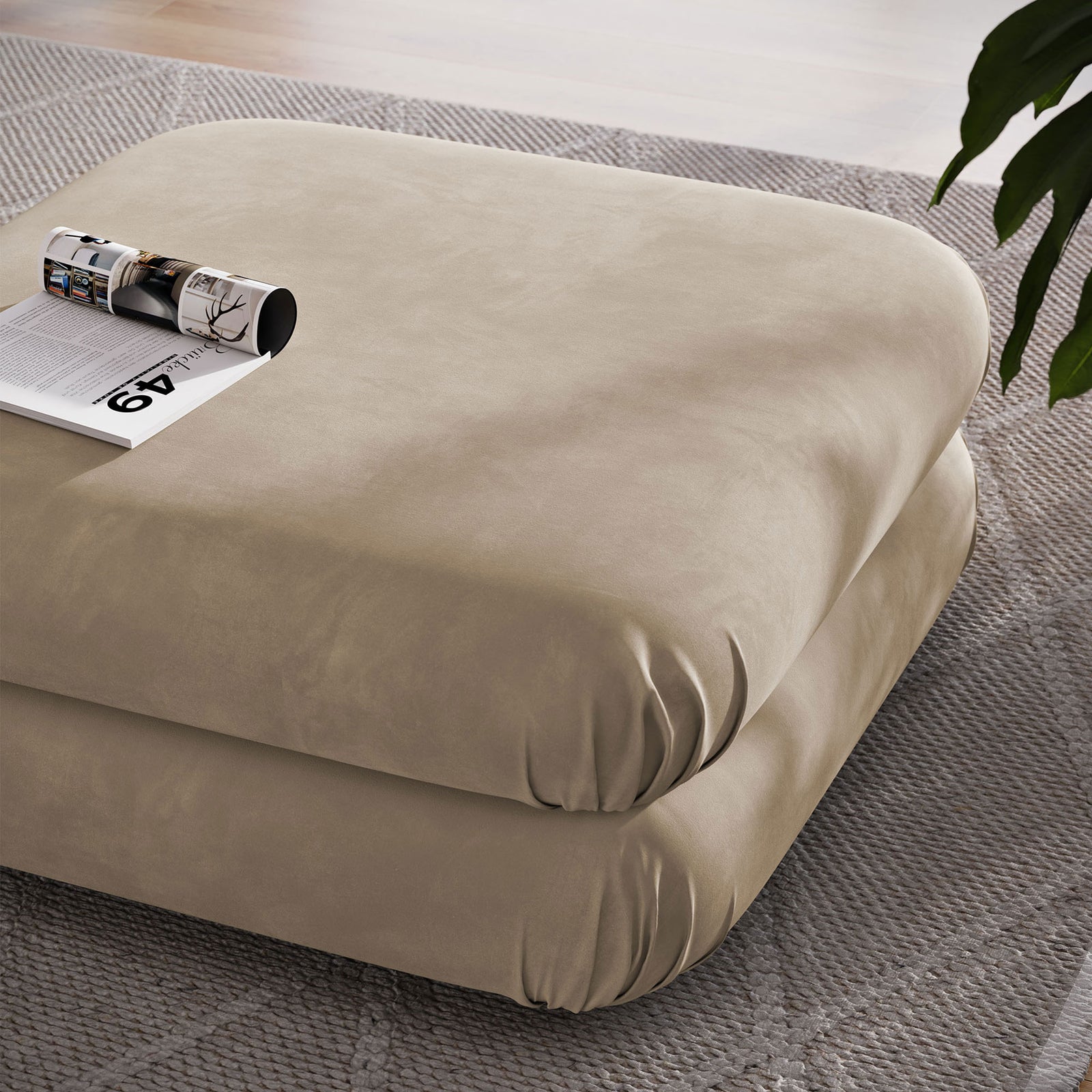 Generous square ottoman in taupe velvet used as a coffee table with magazine atop in a modern room || EEI-6899-TAU || top_angle_room
