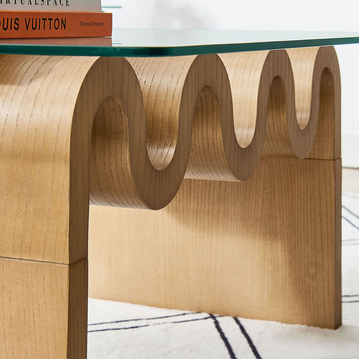 Curved wood base shows rich grain and soft contours under the clear glass surface || EEI-6900-NAT || detail_room