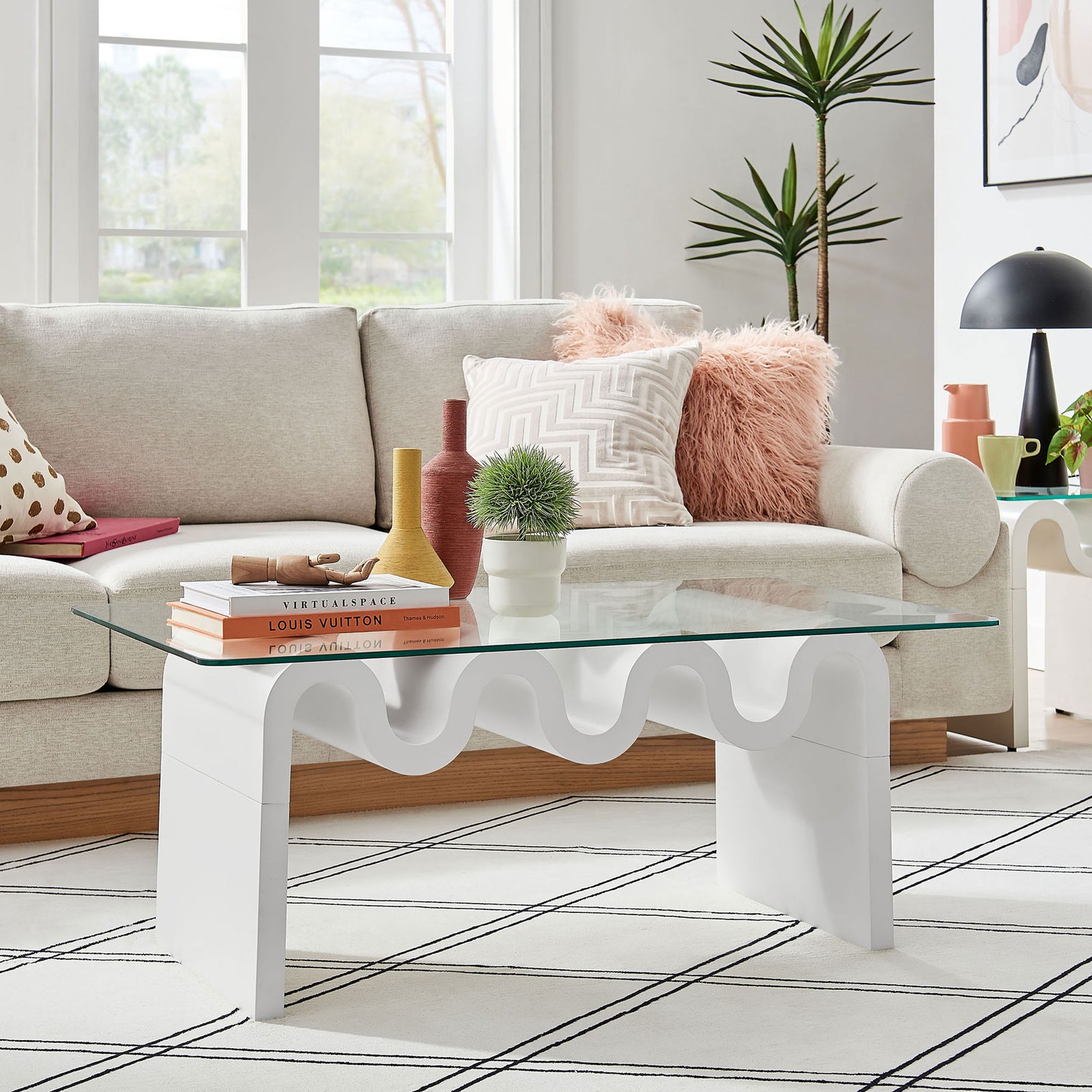 Modern coffee table adds a light, airy presence as the clear glass reveals the playful wave base. || EEI-6900-WHI || front_angle_room