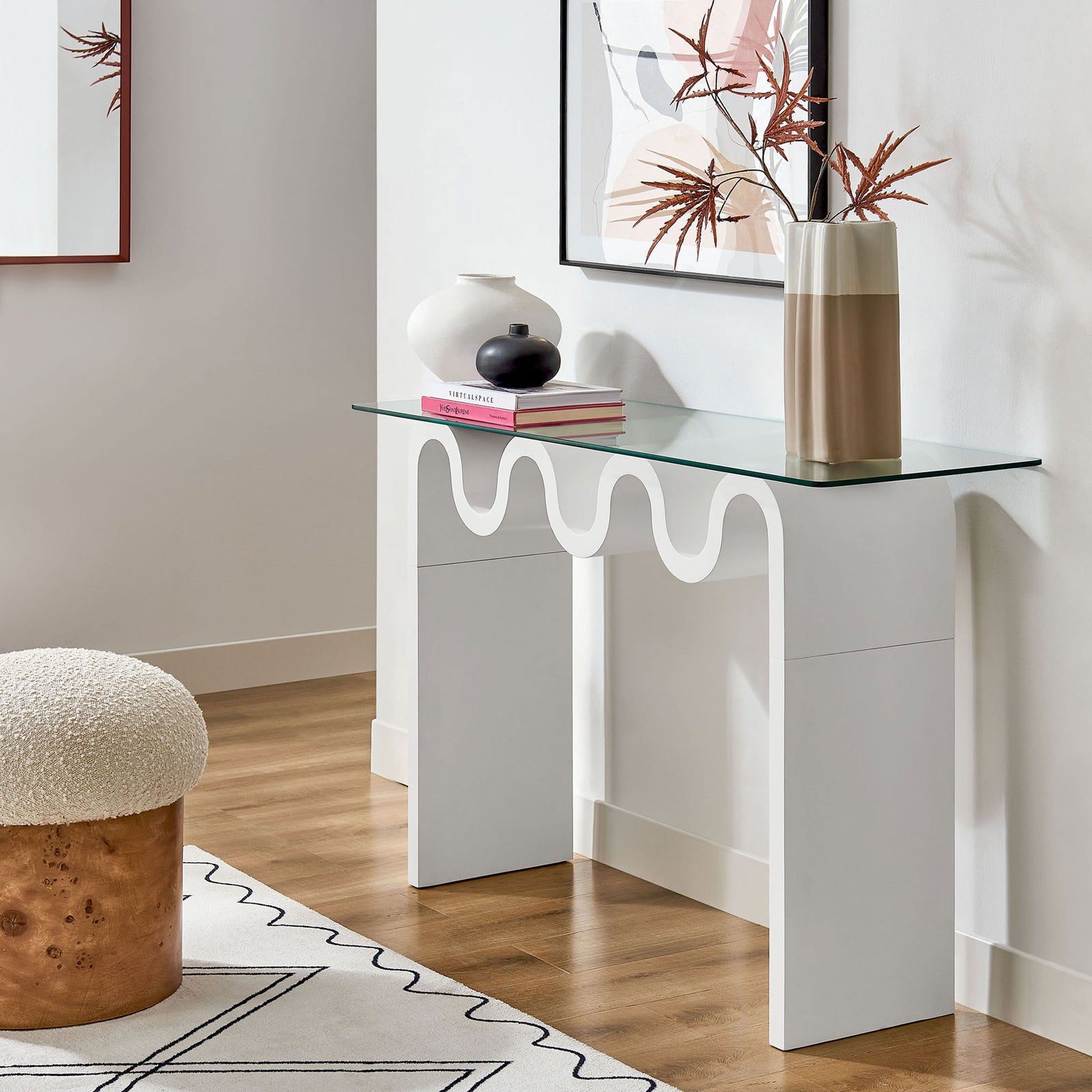 Chic white console elevates entryways with a clear top and playful wave silhouette. || EEI-6901-WHI || front_angle_room