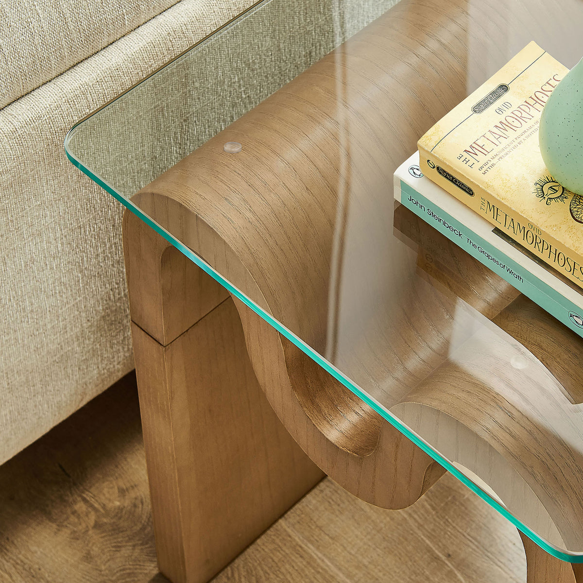 Tempered glass top provides a smooth perch for books and decor while showcasing the sculpted wave base below || EEI-6902-NAT || detail_room