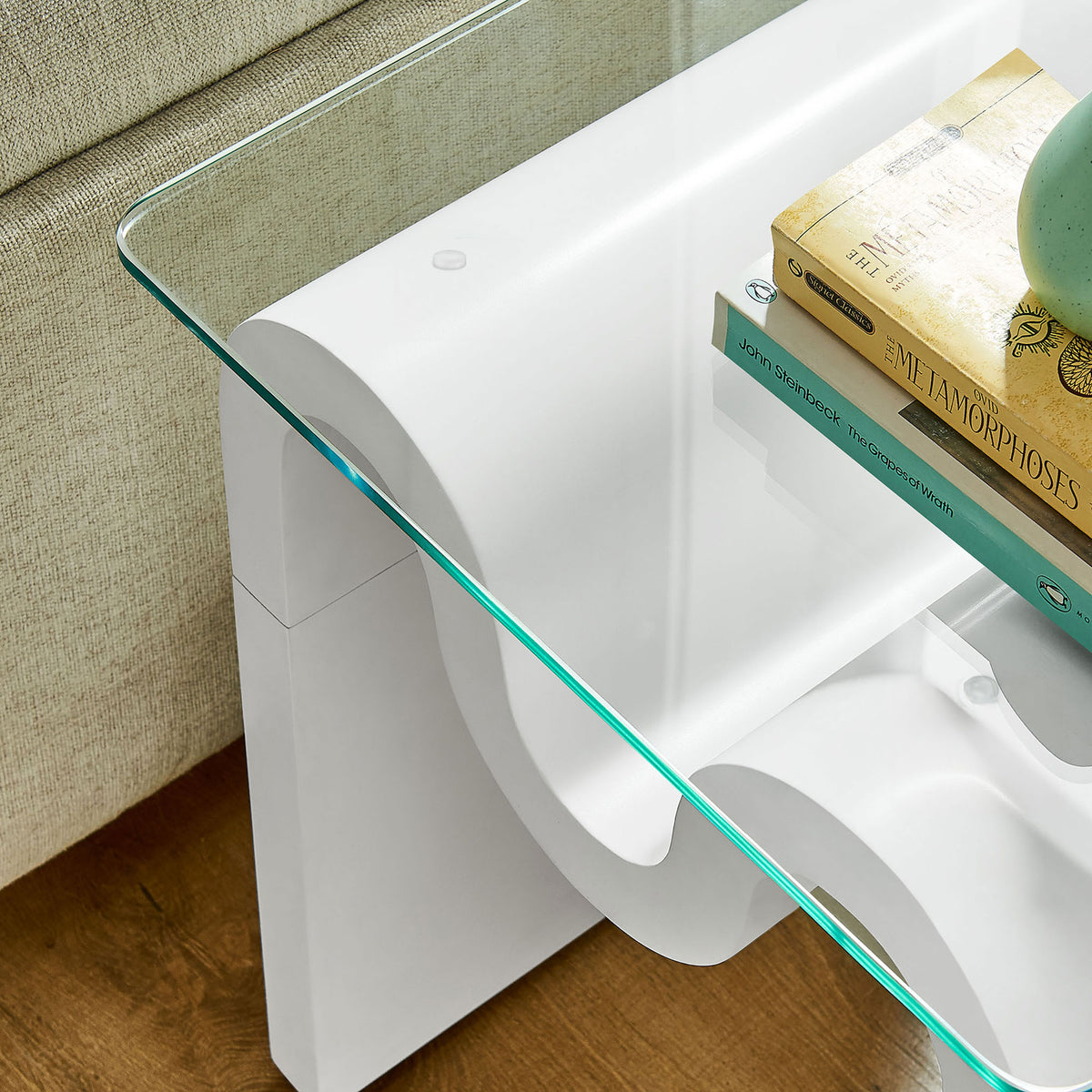 Glass top side table styled with books and decor to highlight its flowing white base || EEI-6902-WHI || detail_room
