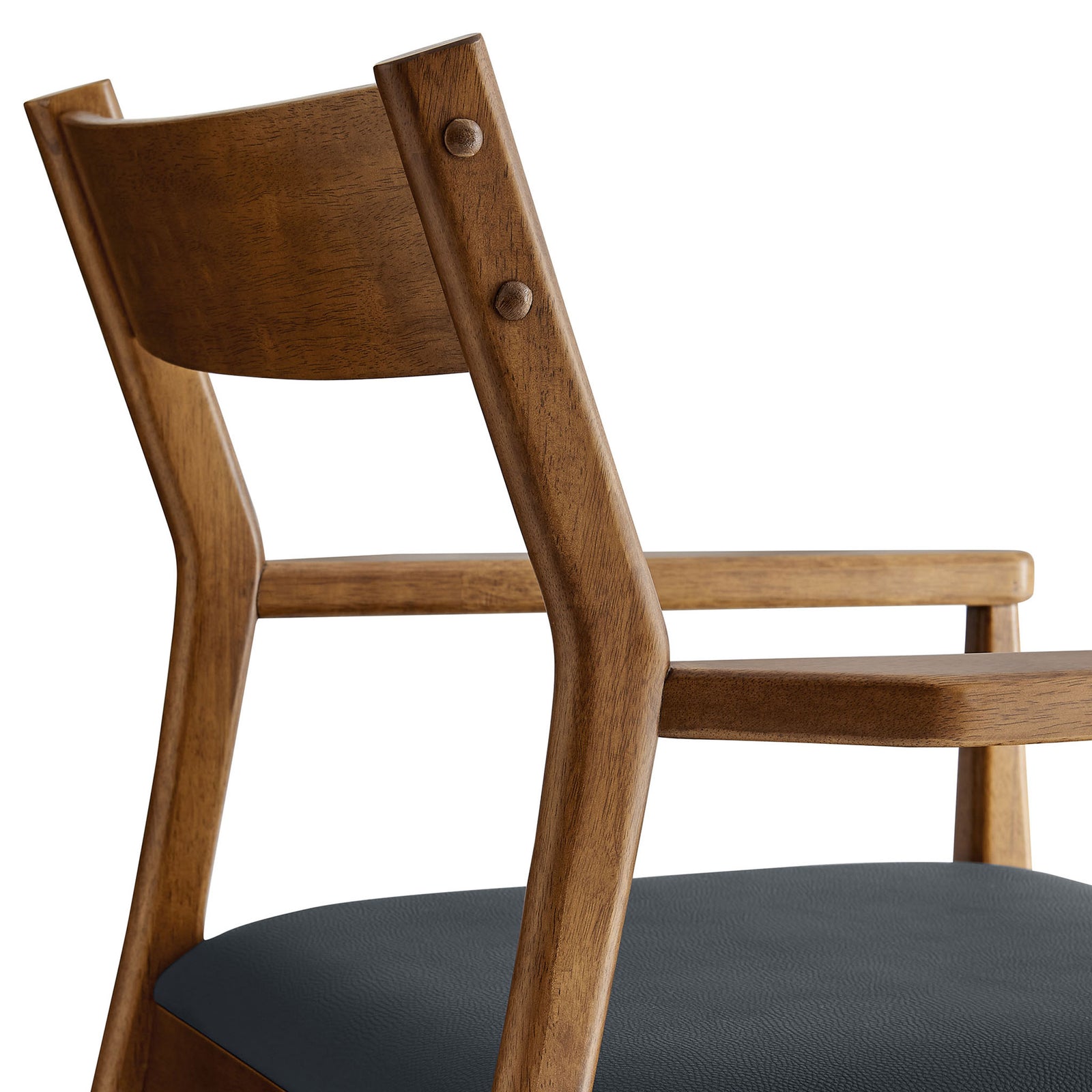 Detail of walnut armchair backrest and arm showing smooth joinery and rounded hardware accents. || EEI-6915-WAL-BLK || detail_studio