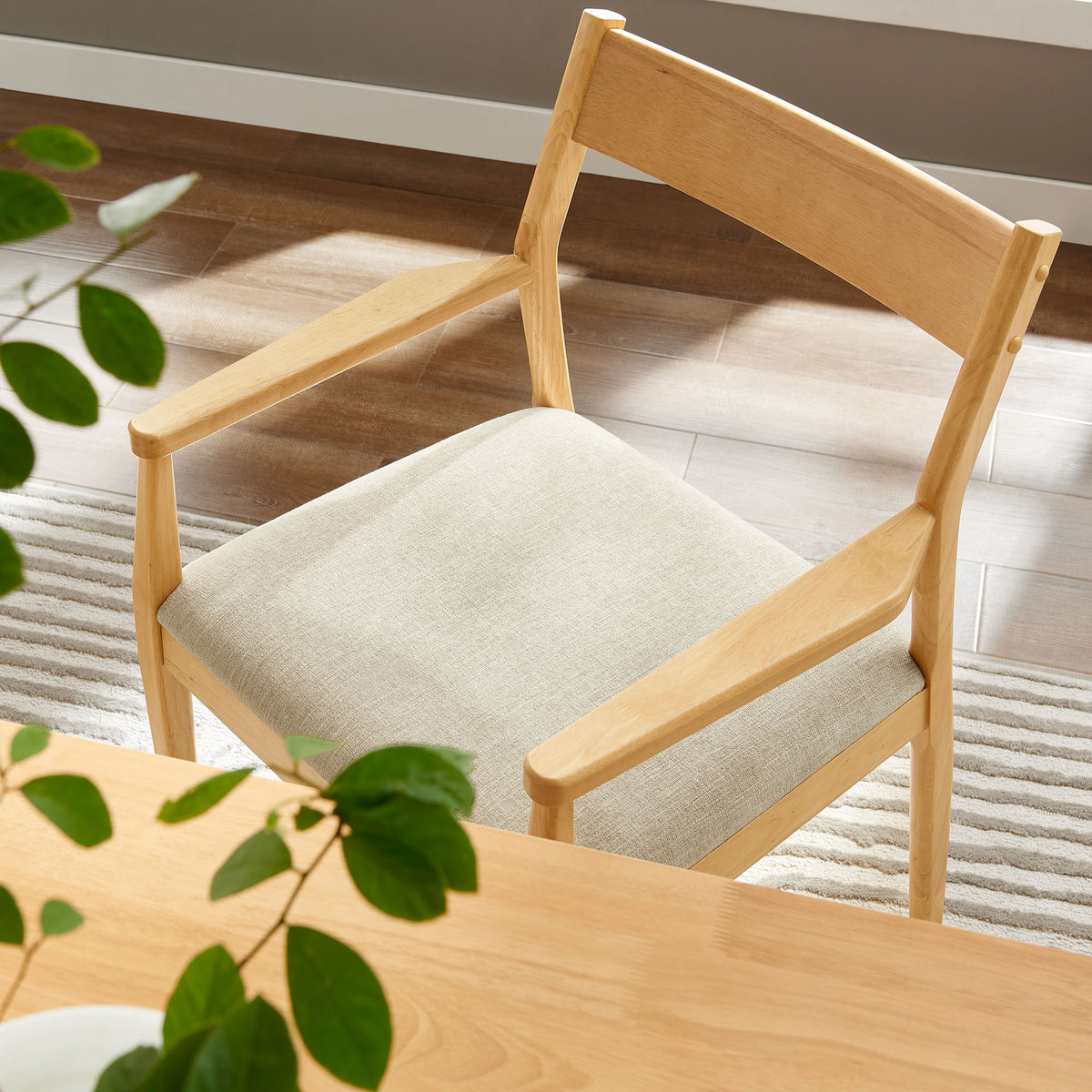 Solara dining armchair tucked at a light wood table with heathered beige cushion in a bright dining room. || EEI-6916-NAT-HEB || detail_room