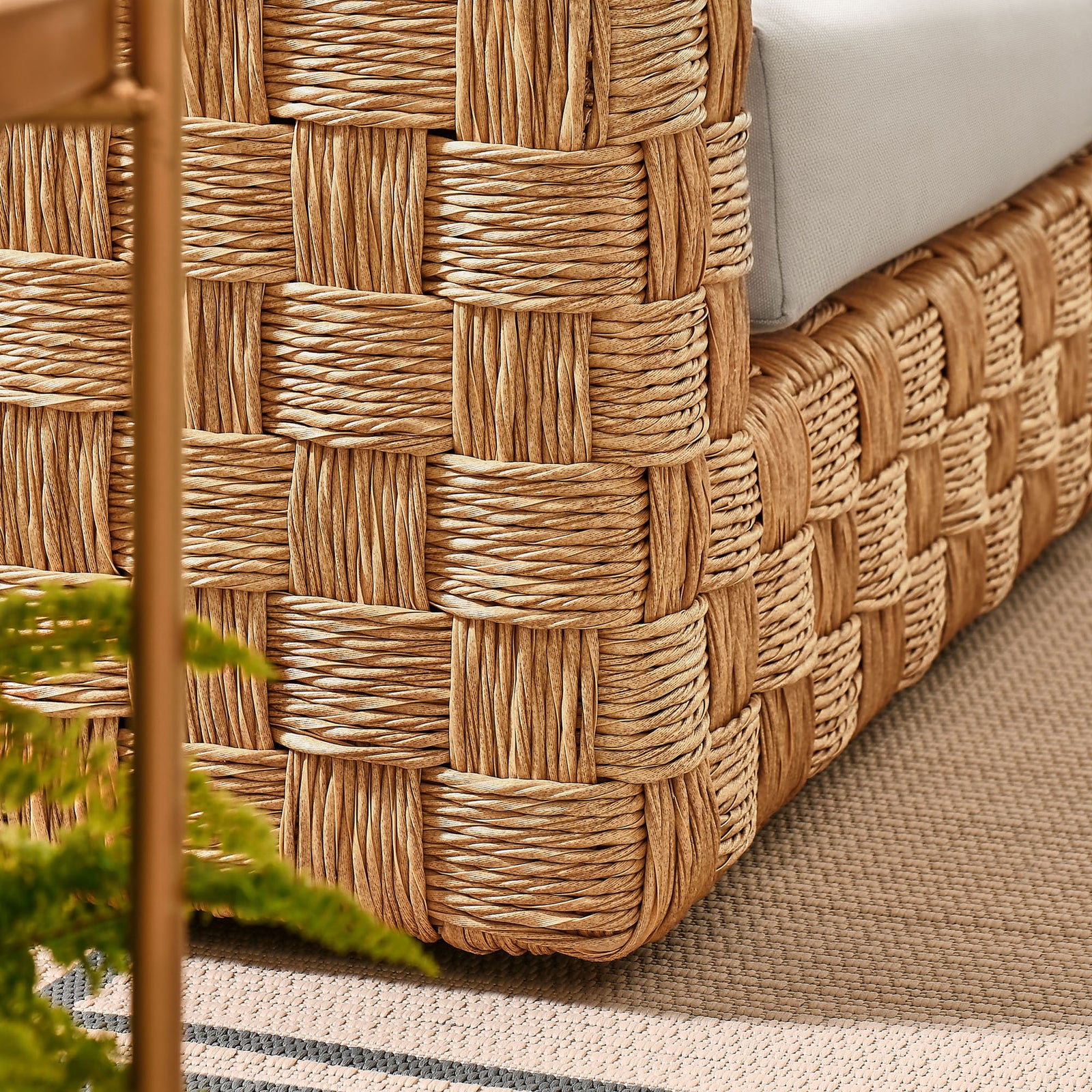 Natural rattan base rests on an outdoor rug, highlighting warm tones and relaxed coastal style. || EEI-6924-NAT-LGR || detail_room