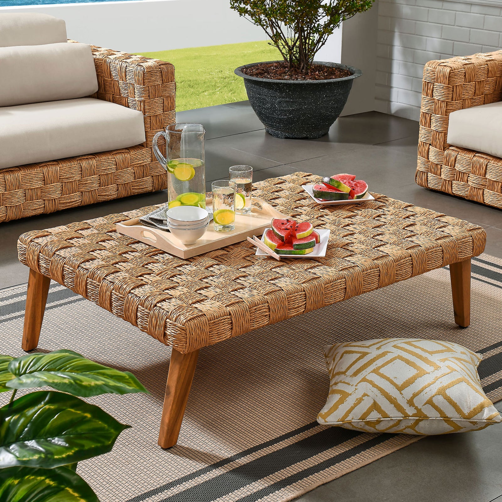 Coffee table arranged in an outdoor lounge setting, perfect for serving snacks and refreshing drinks || EEI-6926-NAT || front_angle_room