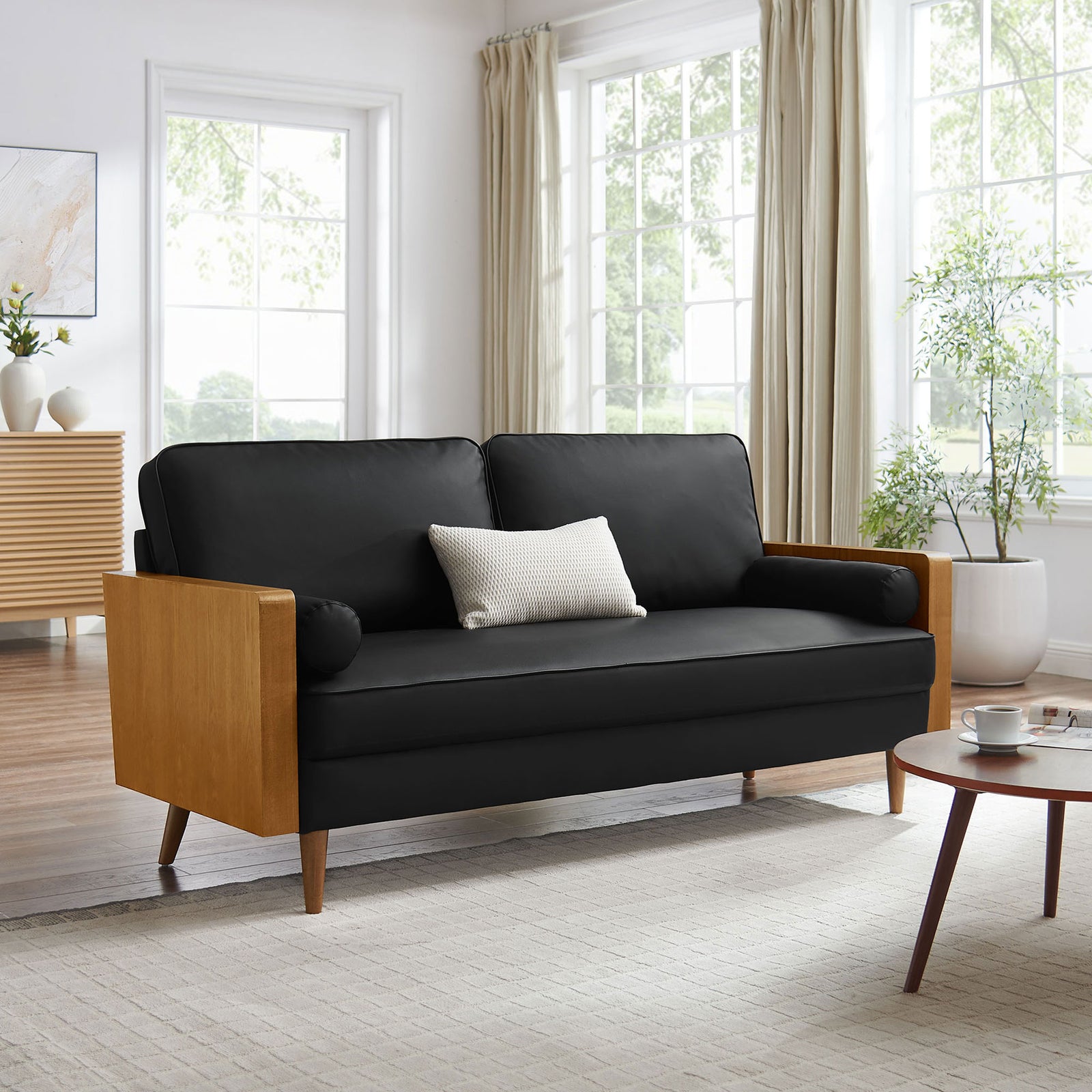 Black vegan leather sofa with walnut arms styled in a bright living room for inviting mid-century charm || EEI-6942-WAL-BLK || front_angle_room