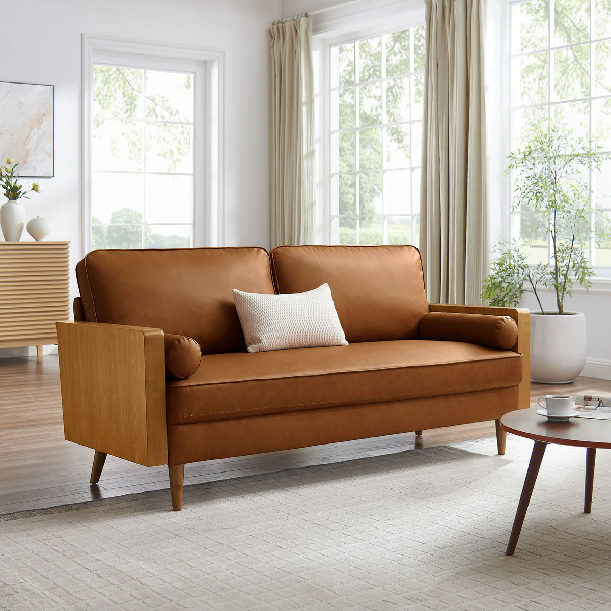 Walnut tan Kellan vegan leather sofa anchors a bright living room with warm wood accents and airy modern style || EEI-6942-WAL-TAN || front_angle_room