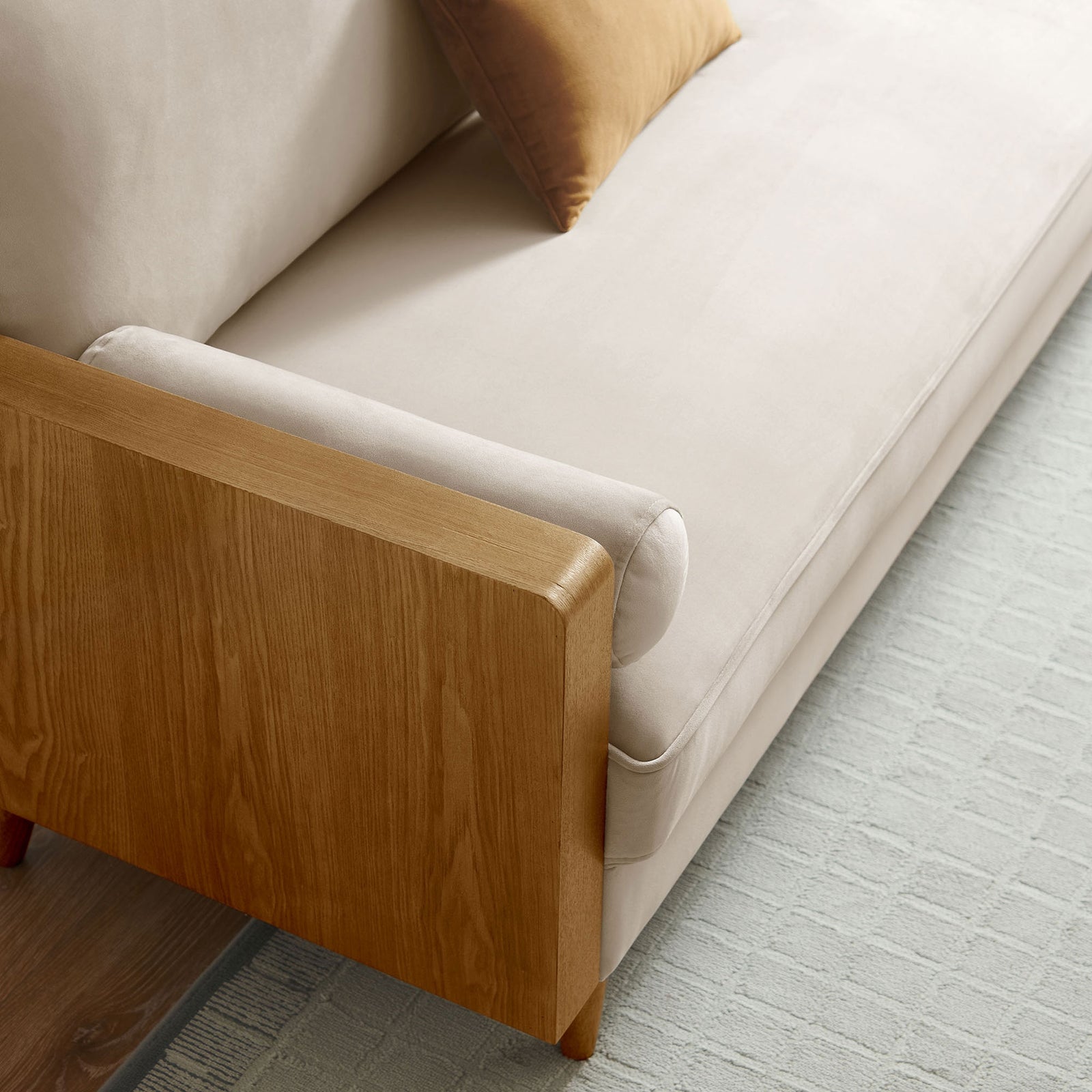 Performance velvet seat and bolster pillow of the Kellan sofa styled with an accent cushion and textured area rug || EEI-6944-WAL-ALM || detail_room