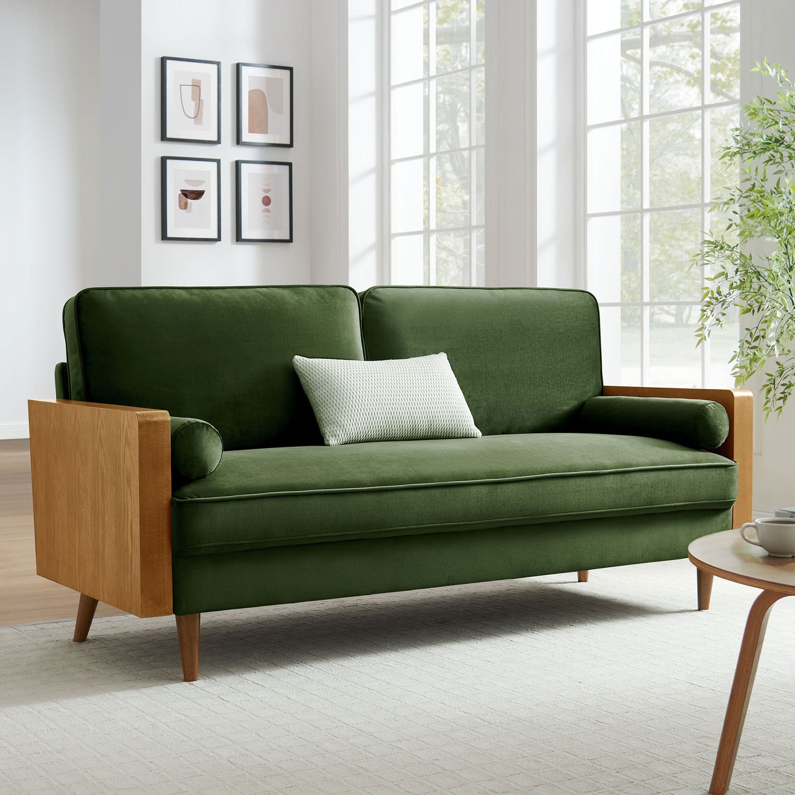 Green velvet sofa with walnut wood arms styled in a bright living room with large windows || EEI-6944-WAL-MOG || front_angle_room