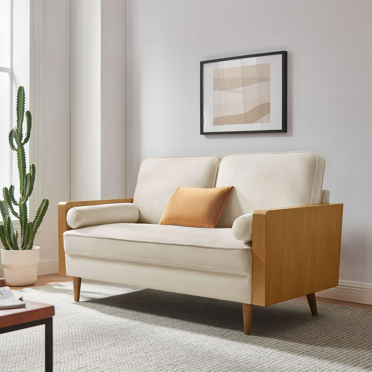 Cream velvet loveseat with walnut arms styled in a bright modern living room with artwork and greenery || EEI-6945-WAL-ALA || front_angle_room