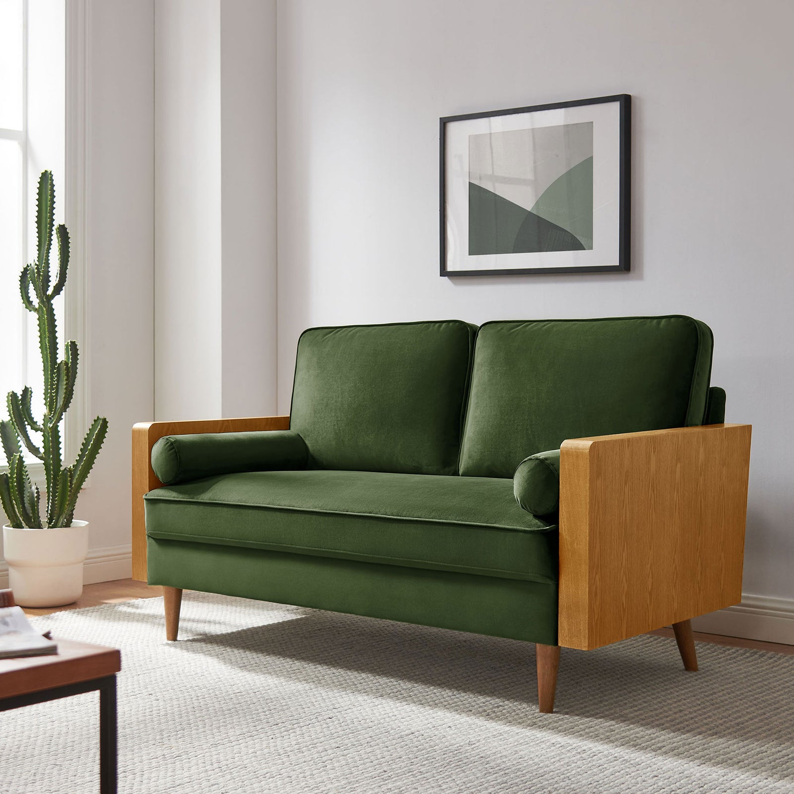 Moss green velvet loveseat in a modern living room with cactus plant and wall art || EEI-6945-WAL-MOG || front_angle_room