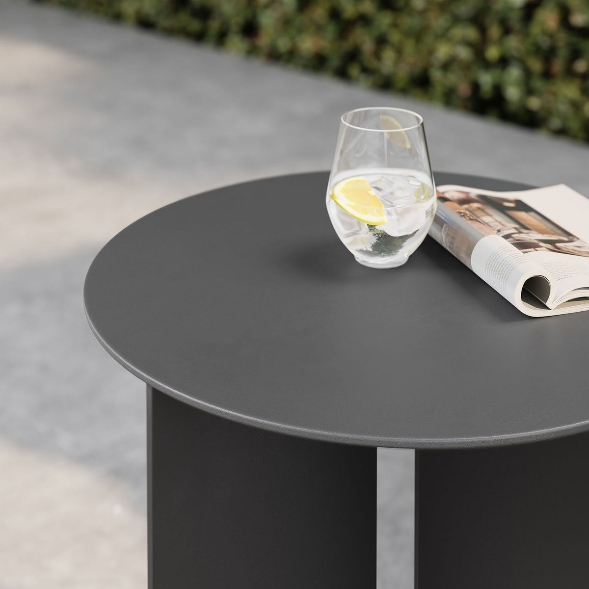 Charcoal outdoor side table top styled with drink and magazine on sleek patio || EEI-6946-CHA || detail_room