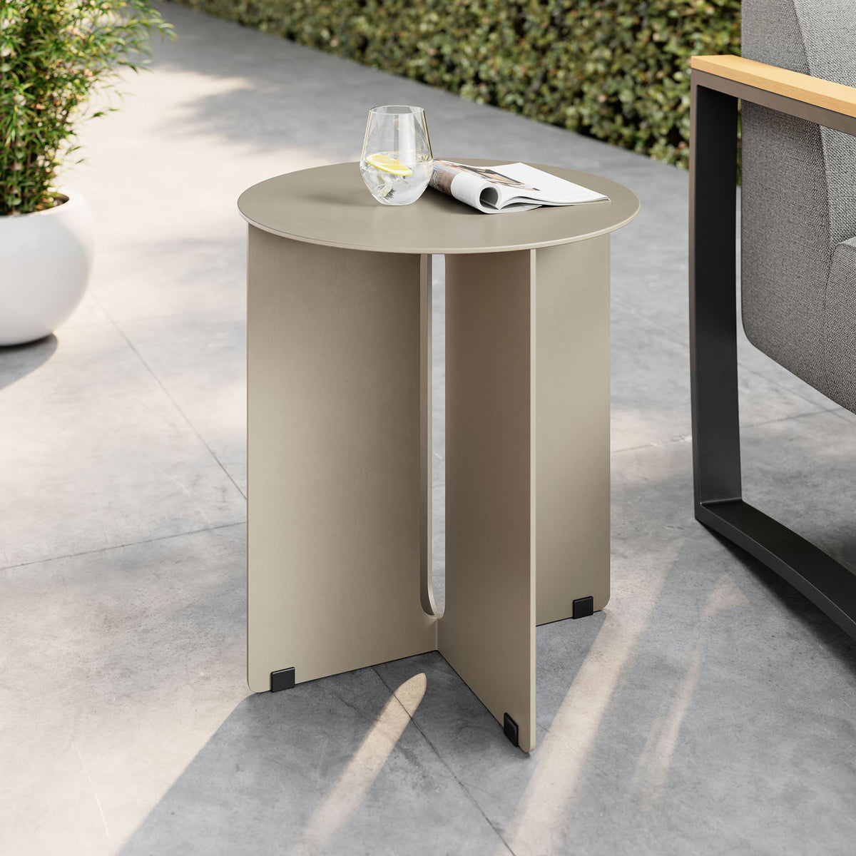 Khaki metal outdoor side table beside cushioned lounge chair on modern patio || EEI-6946-KHA || front_angle_room