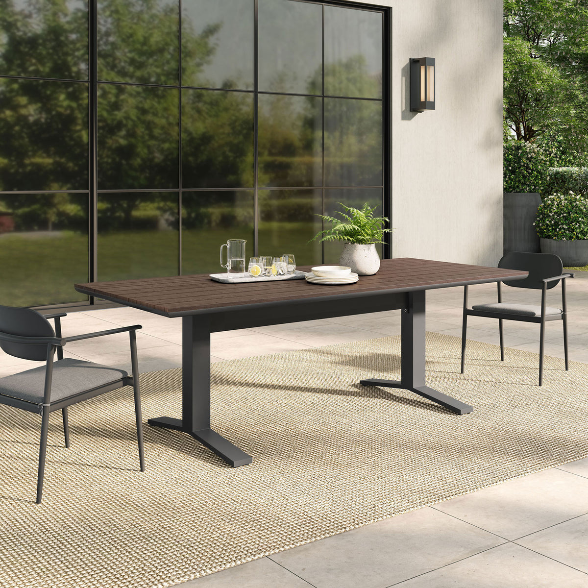 Gavelston gray wash outdoor dining table styled on a modern patio with coordinating chairs and greenery. || EEI-6948-GWA-GRY || front_angle_room