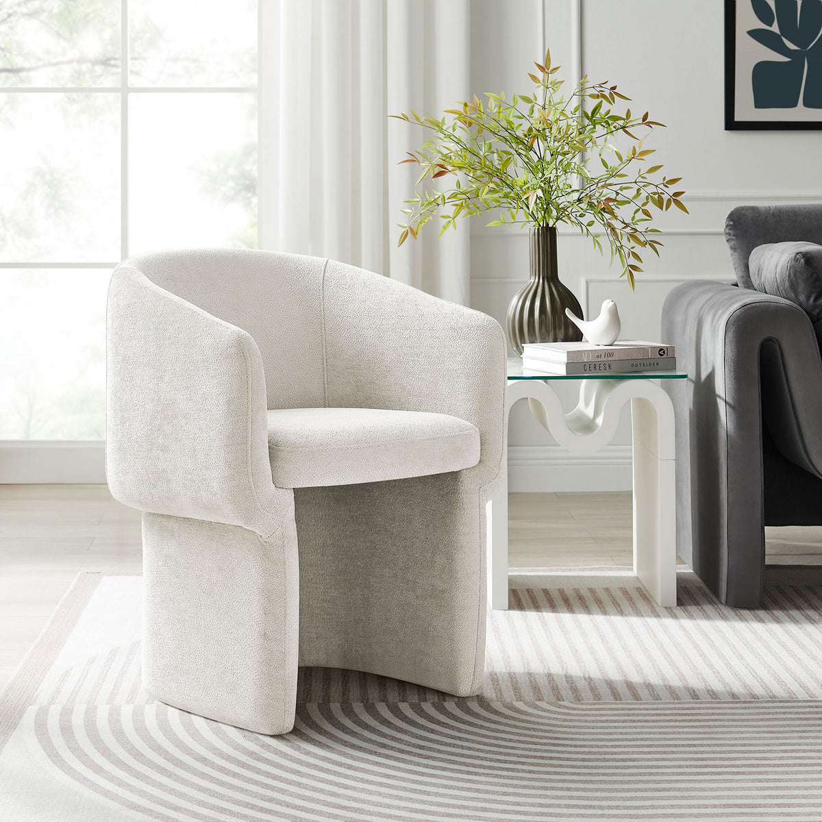 Ivory chenille barrel dining armchair pairs with a sculptural side table to soften a bright contemporary living space || EEI-6951-IVO || front_angle_room