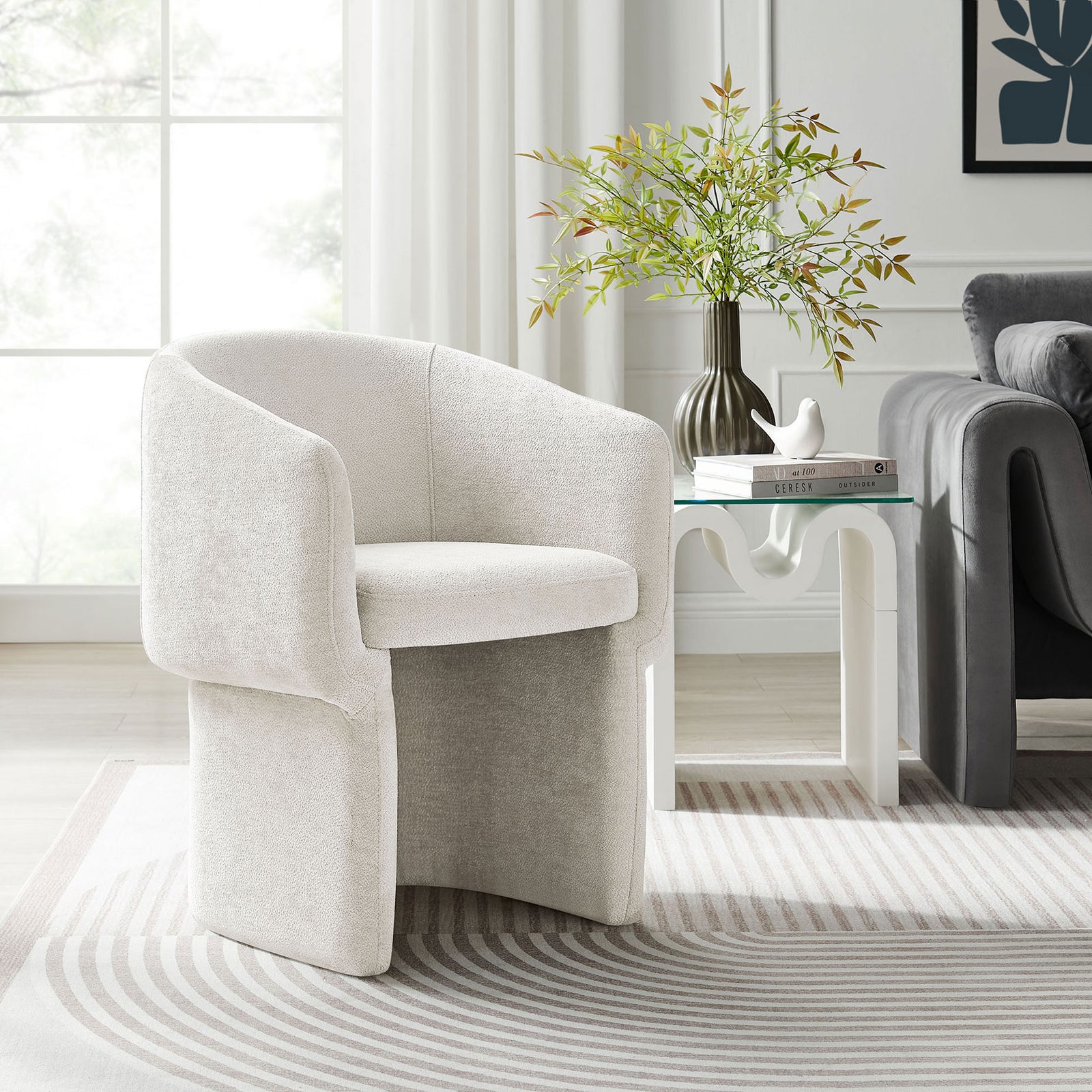 Ivory chenille barrel dining armchair pairs with a sculptural side table to soften a bright contemporary living space || EEI-6951-IVO || front_angle_room
