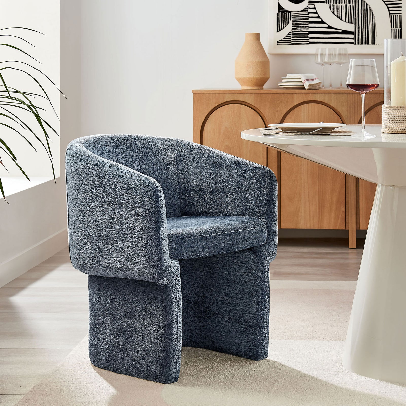 Slate blue barrel dining armchair paired with a modern dining table in a light-filled dining room || EEI-6951-SLA || front_angle_room