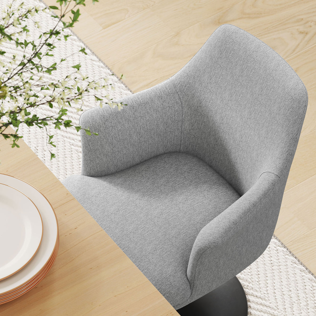 Gray upholstered armchair tucked at a dining table over a textured woven rug || EEI-6956-BLK-HLG || detail_room