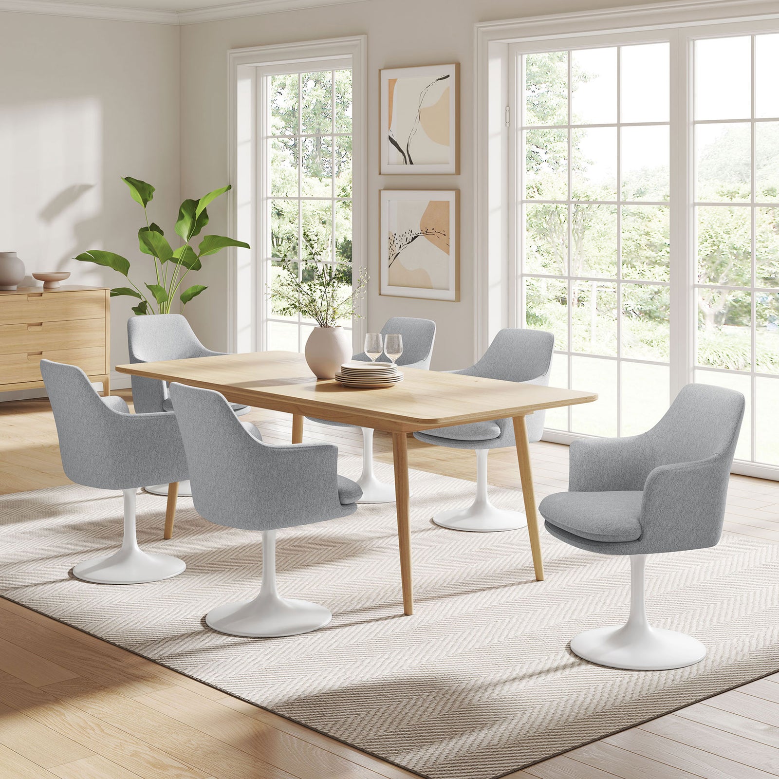 Set of gray pedestal dining armchairs surrounding a wooden table in an airy, light filled dining room. || EEI-6956-WHI-HLG || front_angle_room