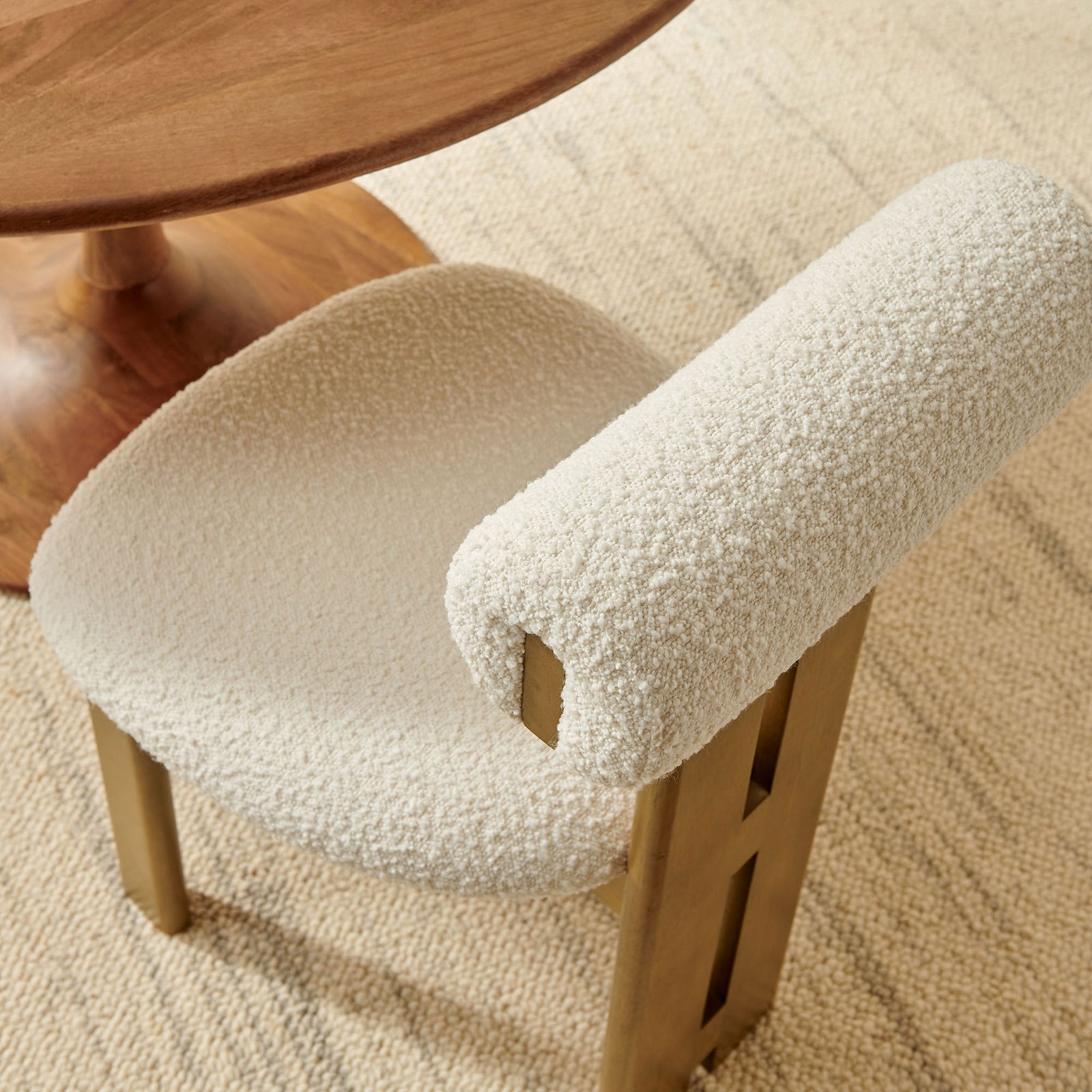 Ivory boucle dining chair styled with a round wood table on a neutral woven area rug || EEI-6960-FRO-IVO || detail_room
