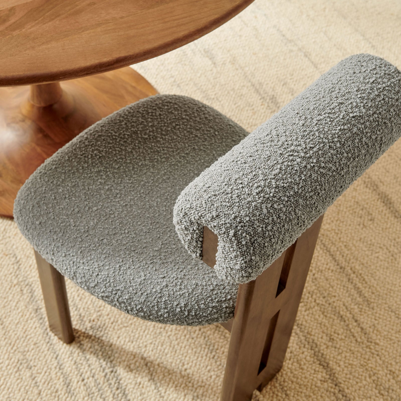 Walnut and gray boucle dining chair styled with round wood table on neutral woven rug || EEI-6960-WAL-LGR || detail_room