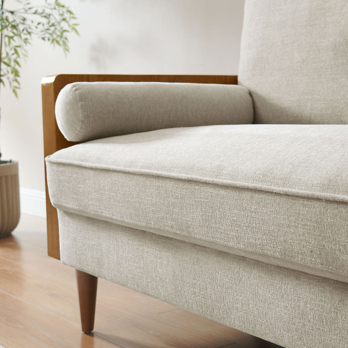 Seat and bolster of the loveseat styled in a cozy room with wood flooring and leafy plant nearby || EEI-6962-WAL-HEI || detail_room