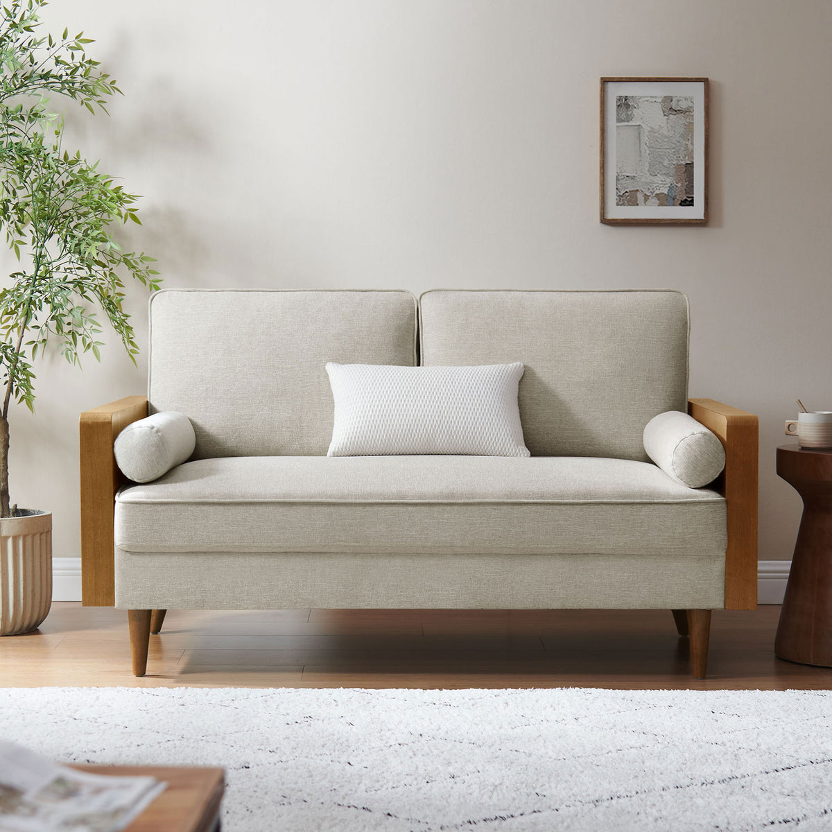 Loveseat in a modern living room with ivory cushions, bolster pillows, and warm wood armrests || EEI-6962-WAL-HEI || front_room