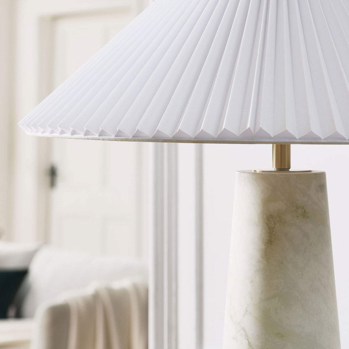 Nera white marble table lamp adding a serene accent to a bright, minimal living space. || EEI-6963-WHI || detail_room