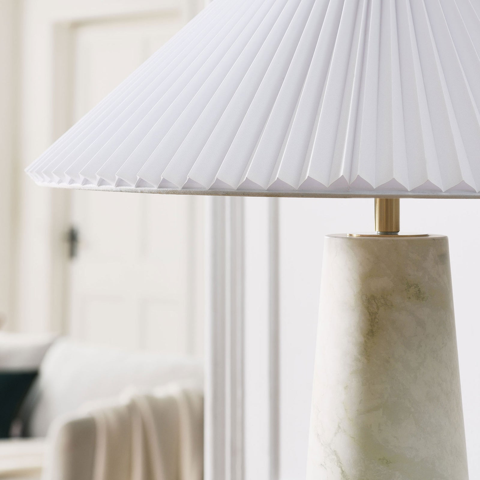 Nera white marble table lamp adding a serene accent to a bright, minimal living space. || EEI-6963-WHI || detail_room