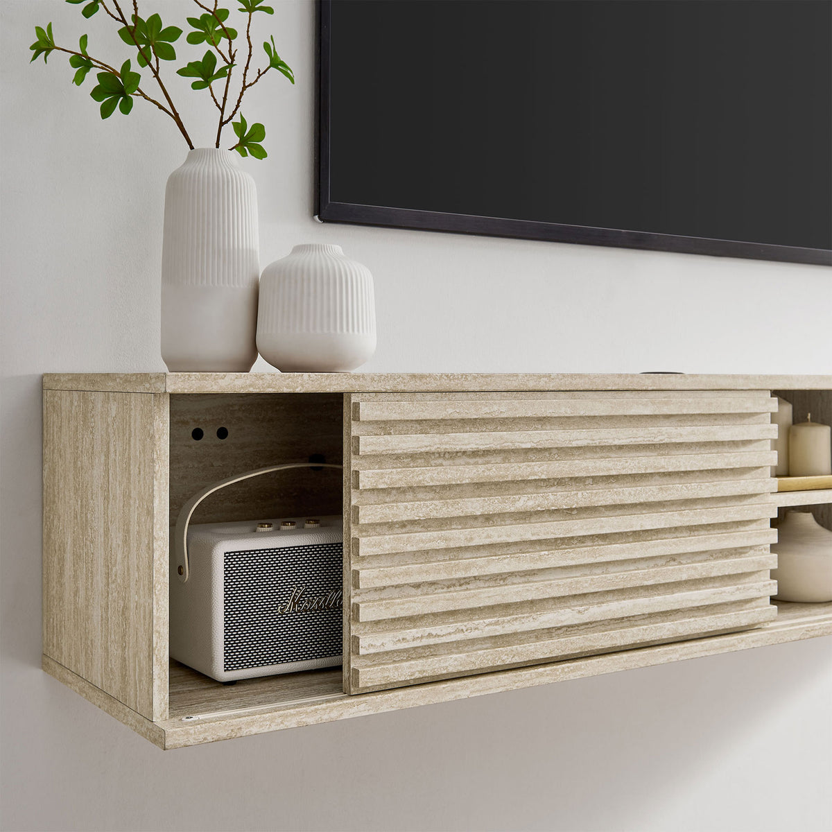 Close-up of the open cabinet bay on the travertine-look console with speaker and ceramic vases. || EEI-6965-TRA || storage_room