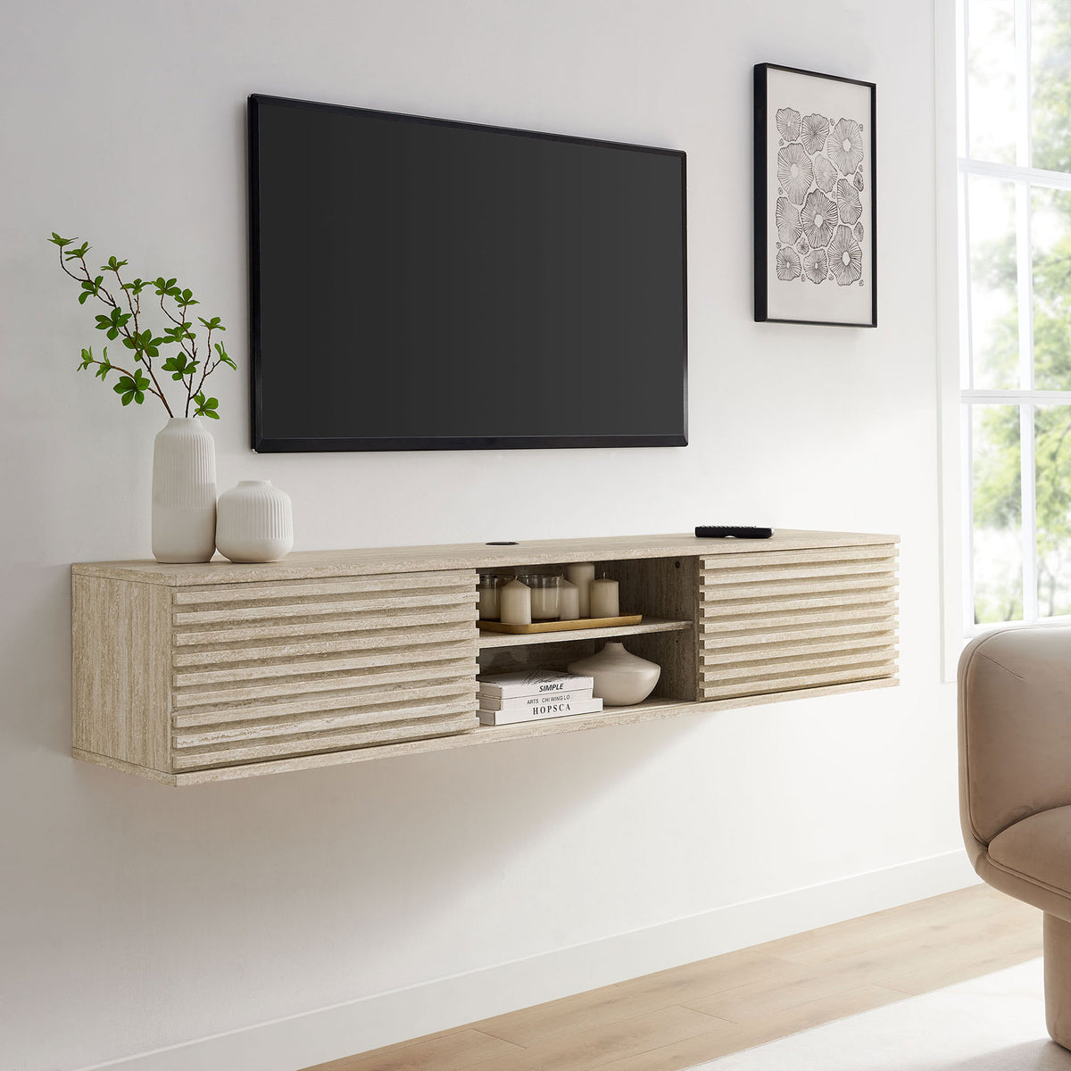 Faux travertine floating media console styled in a bright living room beneath a wall-mounted TV. || EEI-6965-TRA || front_angle_room