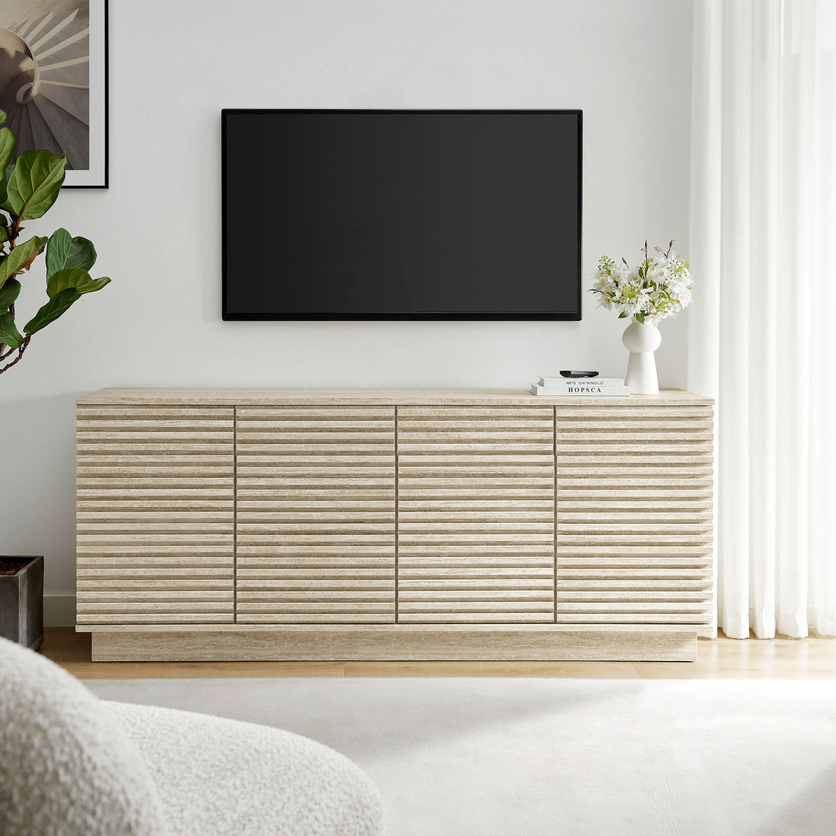 Sideboard styled as a media console beneath a wall mounted TV with decor accents and bright natural light || EEI-6966-TRA || front_room