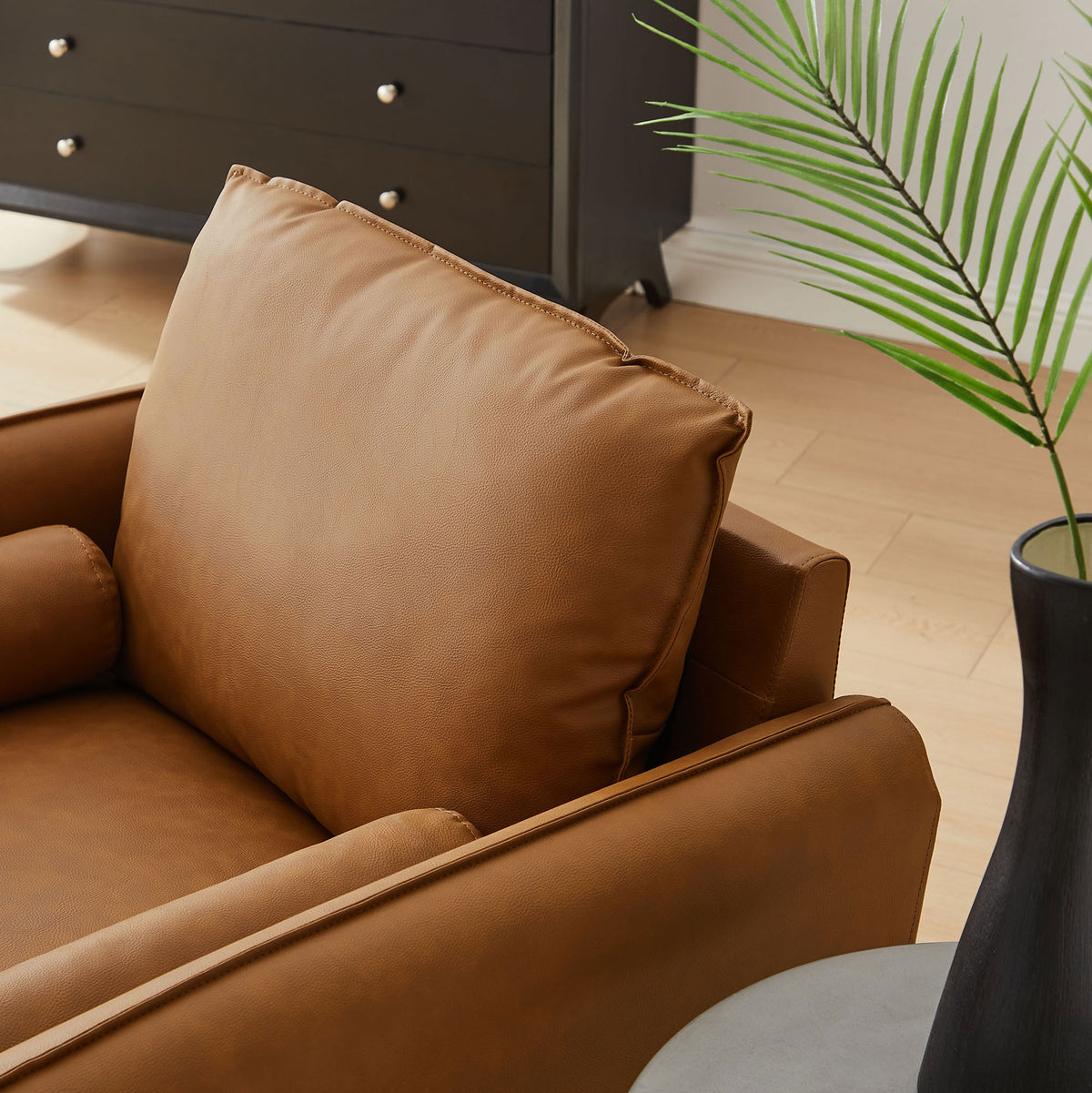 Soft back cushion and round bolster pillow in tan vegan leather for inviting, lounge-ready comfort. || EEI-6973-TAN || detail_room