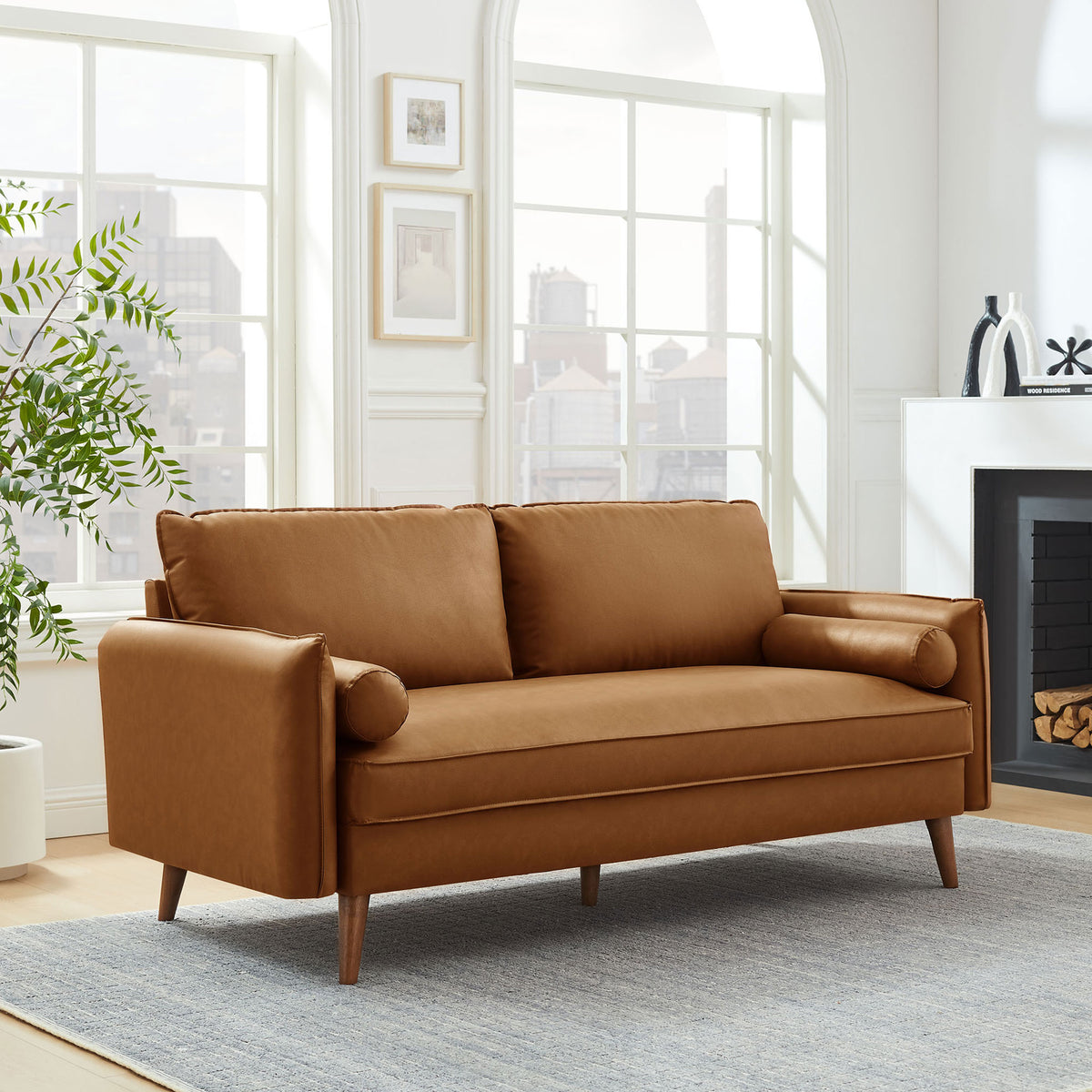 Tan vegan leather mid-century sofa styled in a bright living room with bolster pillows || EEI-6975-TAN || front_angle_room
