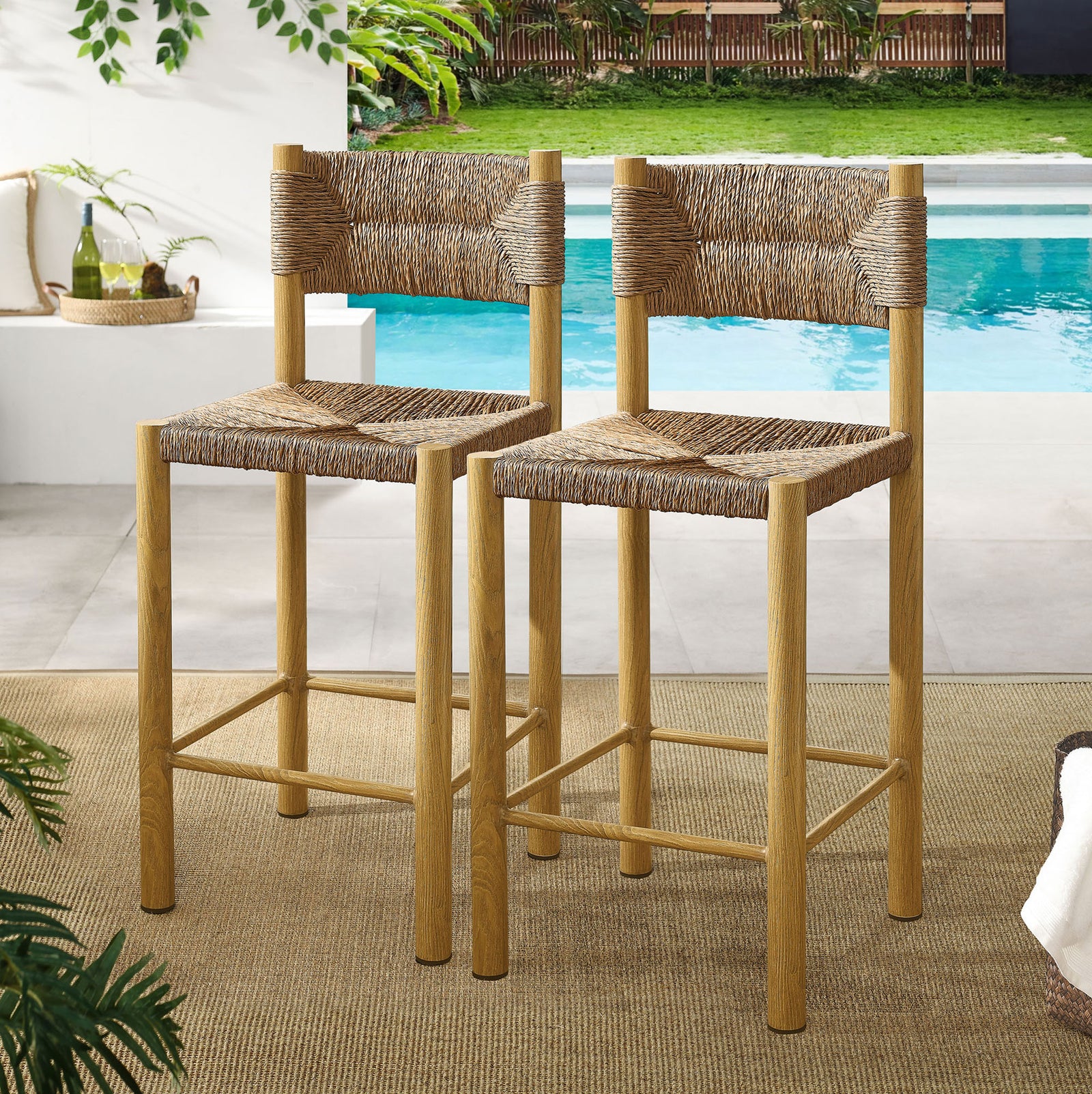 Pair of counter stools anchors an inviting outdoor bar area with warm rattan and wood tones || EEI-6983-NAT || front_angle_multi_room