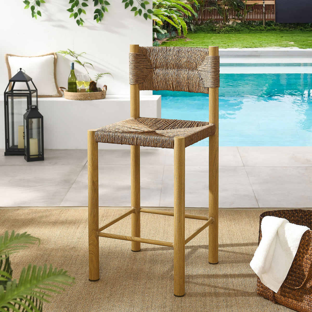 Natural counter stool adds relaxed woven texture to a bright poolside patio setting || EEI-6983-NAT || front_angle_room