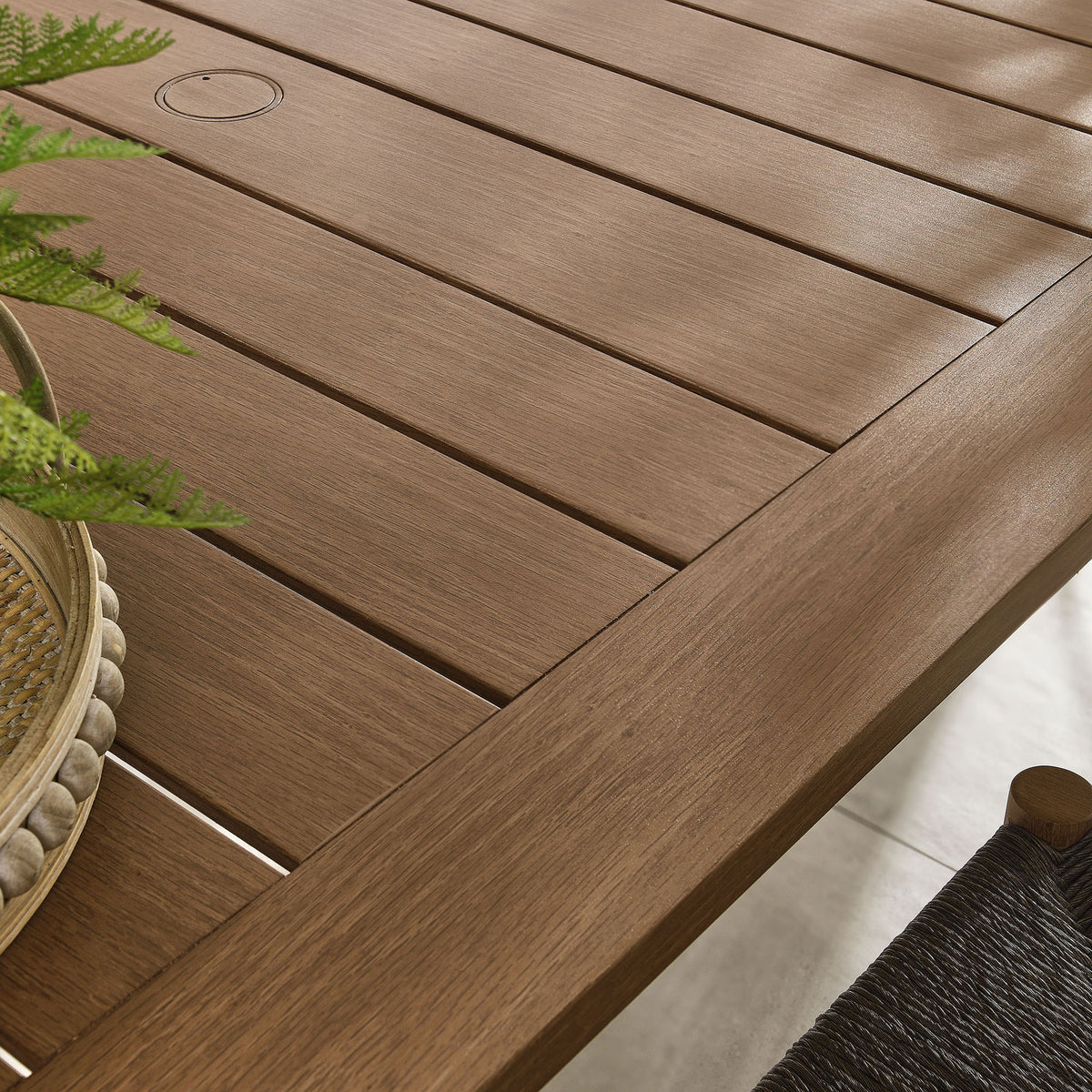 Rich walnut wood-grain slats complement woven chairs and greenery for a cozy outdoor dining nook || EEI-6985-WAL || swatch_room