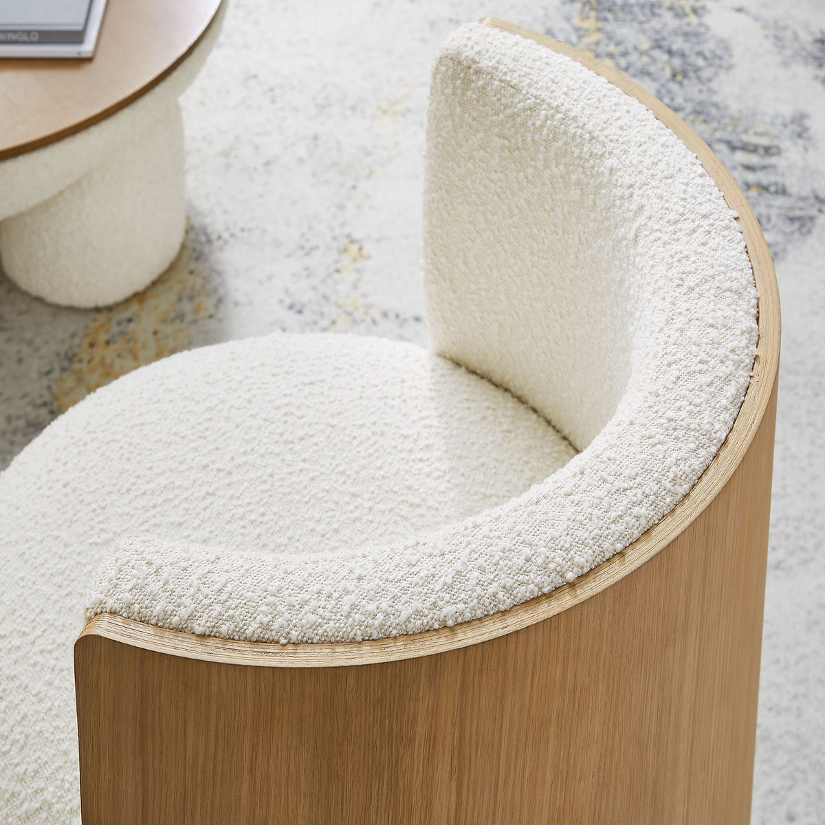 Textured boucle wraps the curved backrest for cozy comfort and tactile appeal || EEI-6994-NAT-IVO || detail_room