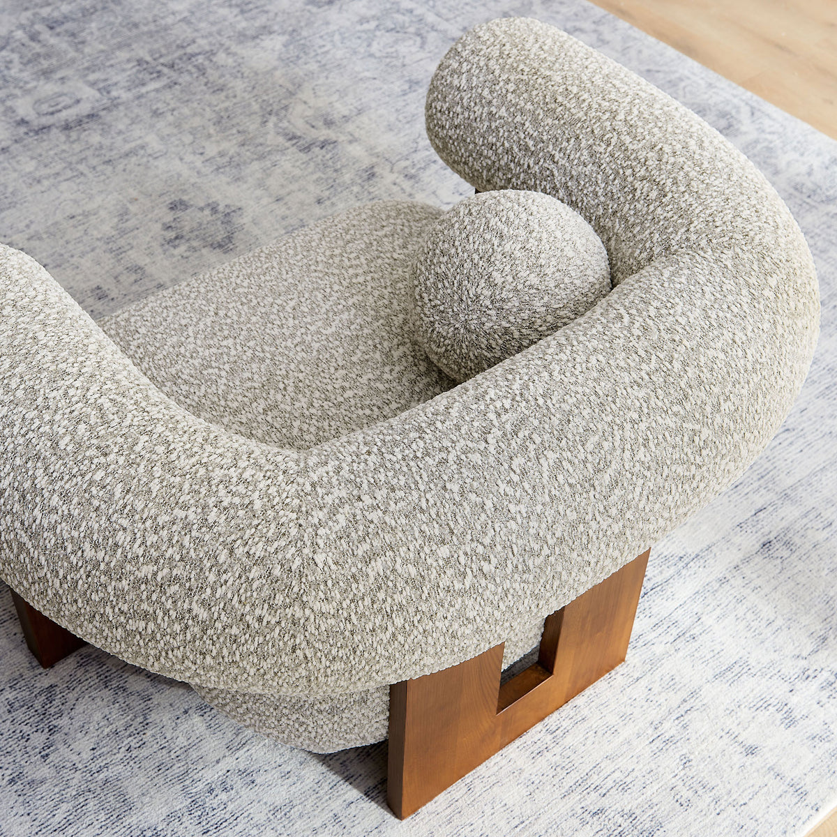 Rounded profile cradles a matching accent pillow, pairing plush boucle texture with sculptural ash wood legs. || EEI-6996-RIV || top_room