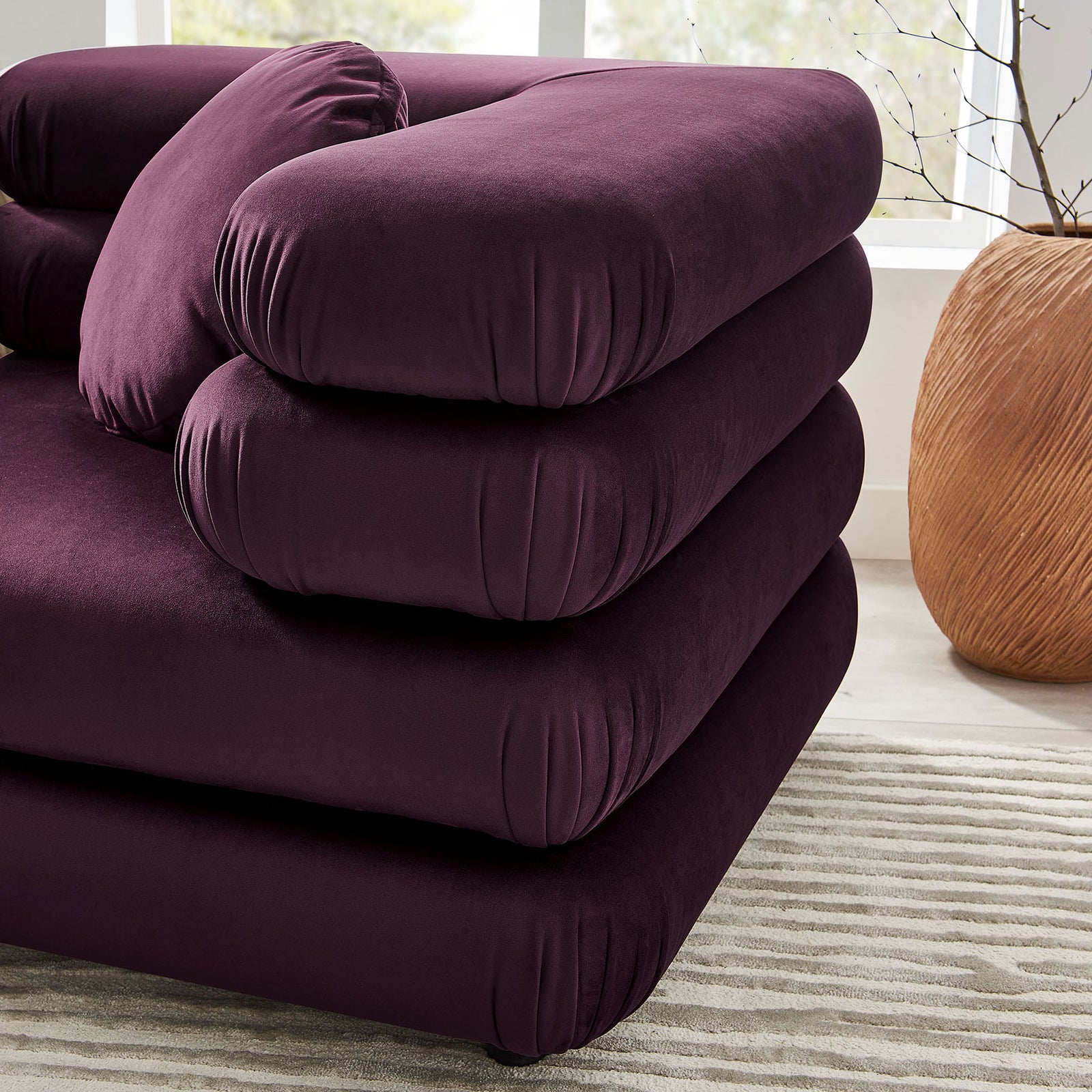 Mulberry velvet corner seat with rounded stacked cushions highlighting the sofa's plush, tailored texture || EEI-7003-MUL || detail_room