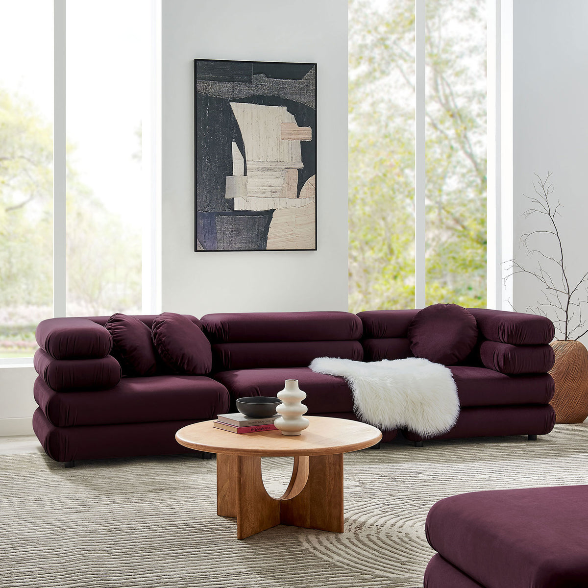 Mulberry velvet modular sectional arranged in an inviting corner layout with layered cushions and soft round pillows || EEI-7003-MUL || front_angle_room