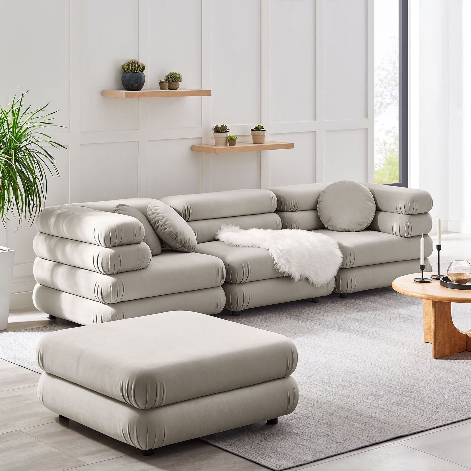 Spacious almond modular sectional with ottoman, layered cushions, and cozy textures in a contemporary living space || EEI-7004-ALM || front_angle_room