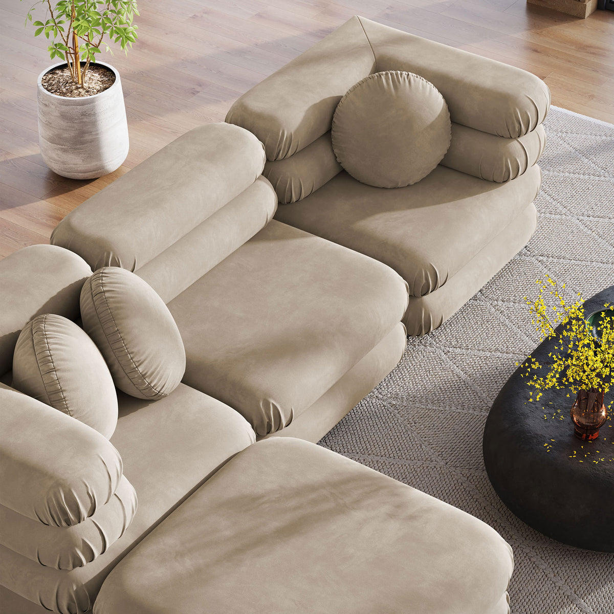 Taupe modular sectional with ottoman and round pillows displaying plush, layered comfort || EEI-7004-TAU || top_angle_room