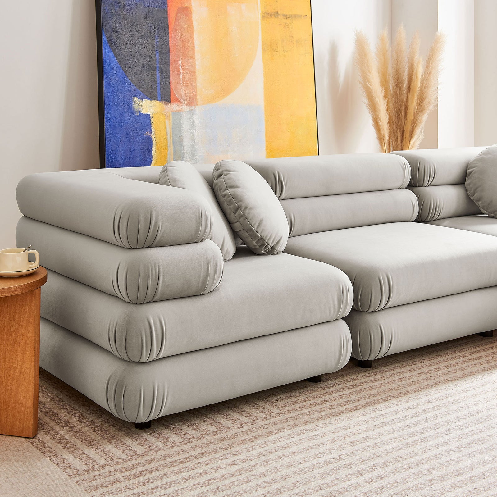 Almond velvet sectional corner with plush layered cushions and matching round bolster pillow || EEI-7005-ALM || detail_room
