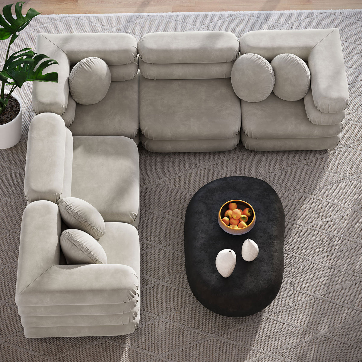 Almond sectional sofa arranged in an L shape over a patterned rug with a dark oval coffee table || EEI-7005-ALM || top_room