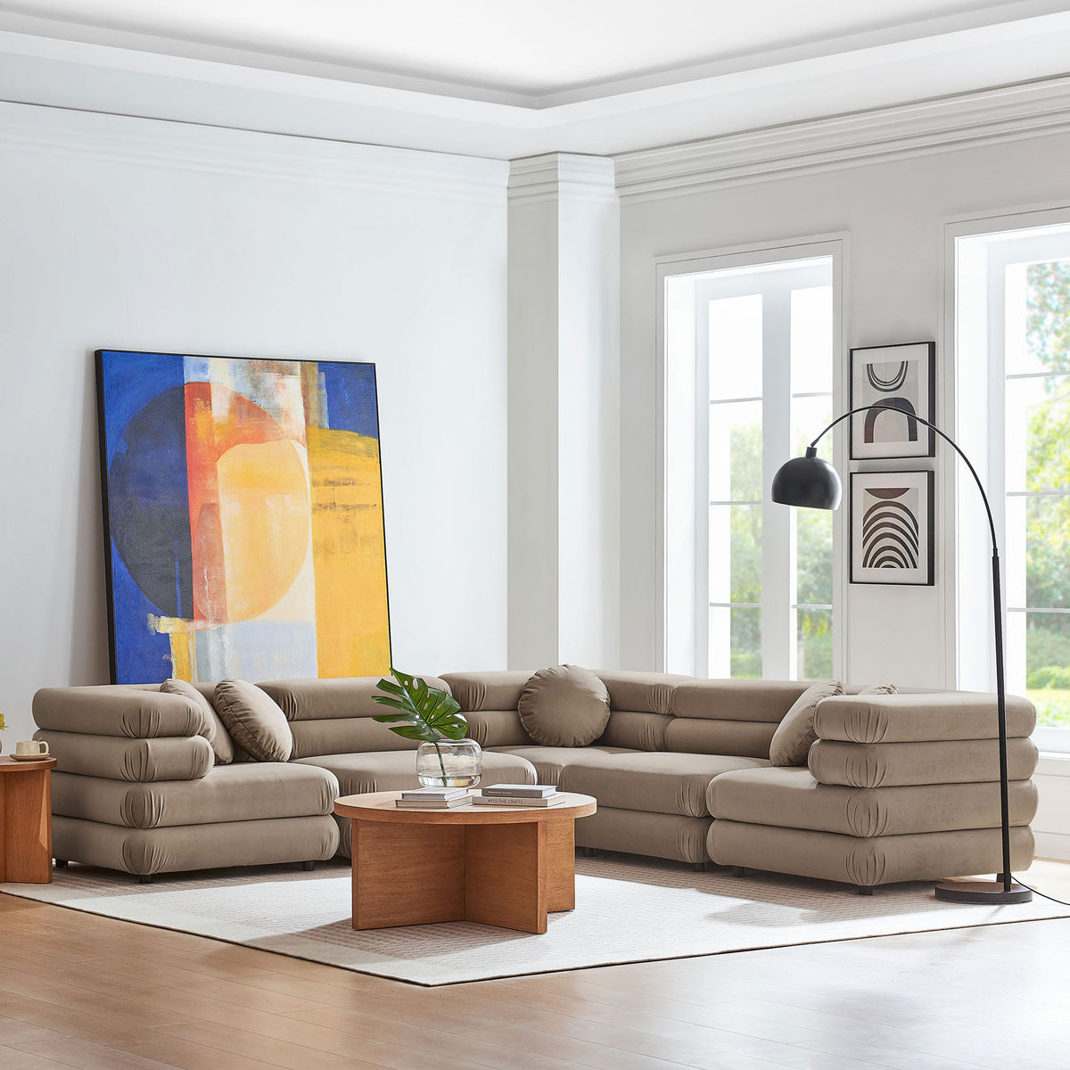 Spacious taupe modular sectional anchored in a bright living room with modern art and wood coffee table || EEI-7005-TAU || front_angle_room