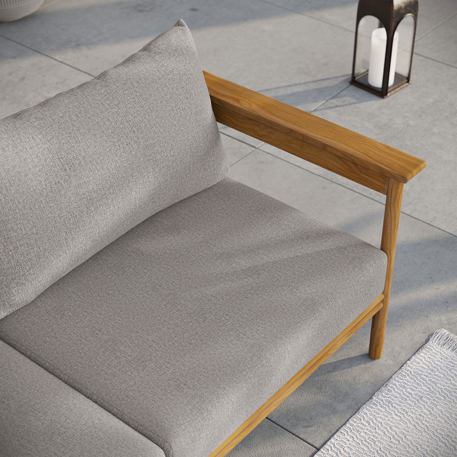 Teak outdoor sofa corner styled with soft gray cushions, lantern lighting, and a cozy patio rug. || EEI-7008-NAT-DRI || detail_room
